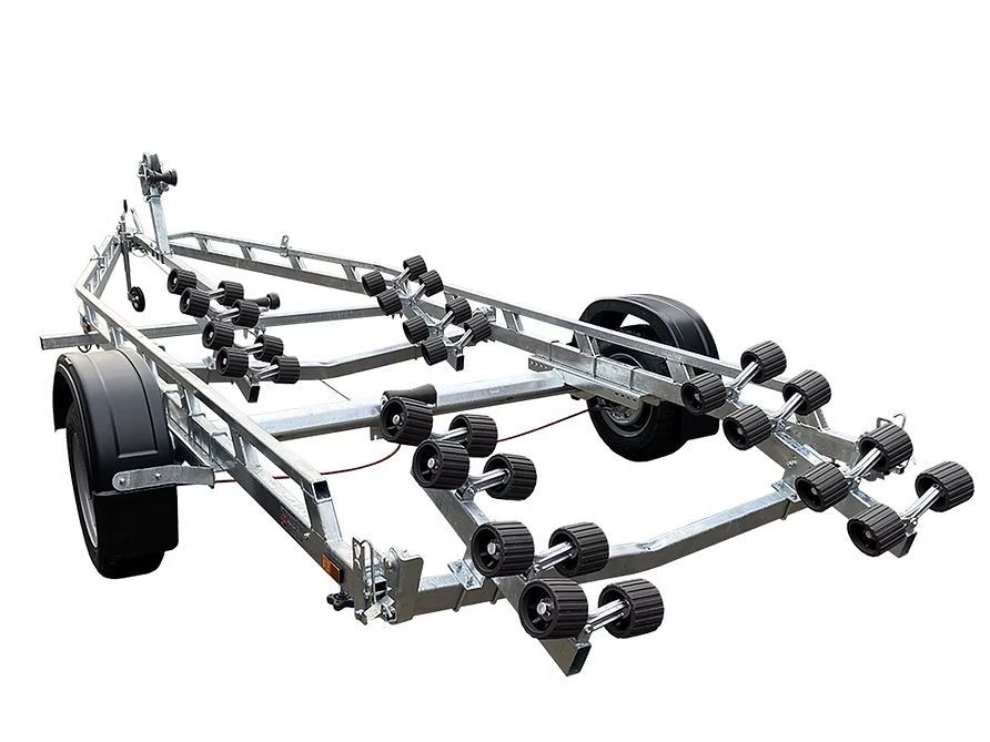 Boat trailer with numerous black rollers, metal frame, and black tires.