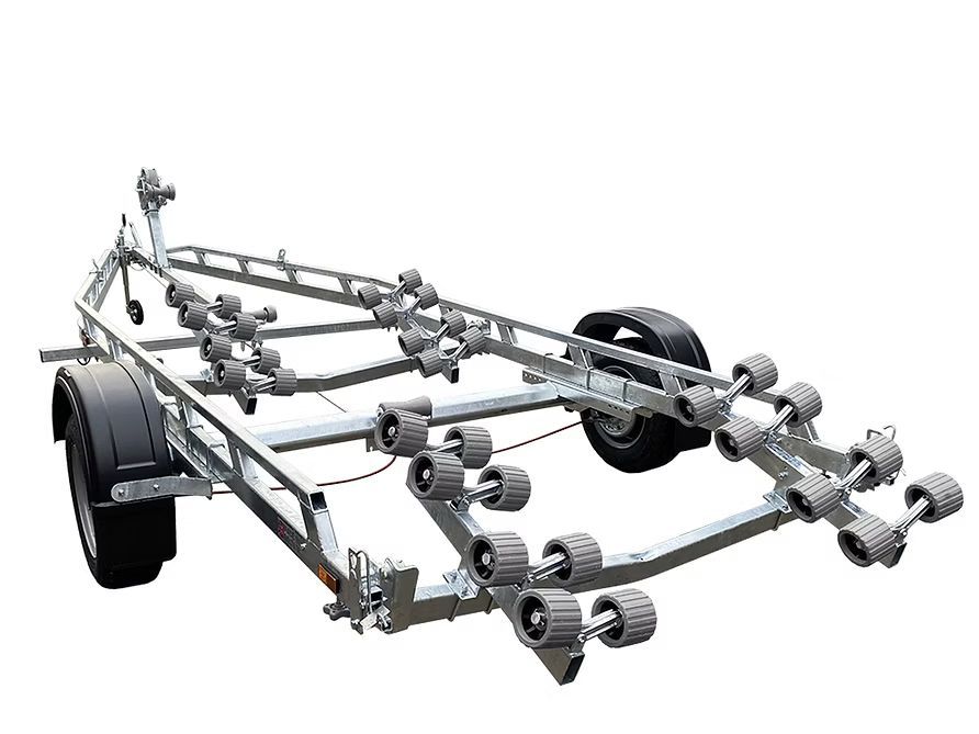 Boat trailer with numerous black rollers, metal frame, and black tires.
