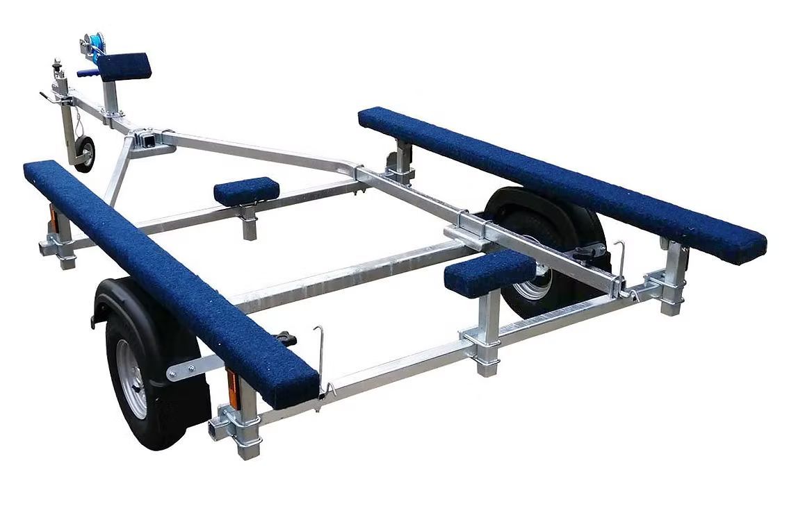 Boat trailer with blue padded supports and fenders, silver frame, and black tires.