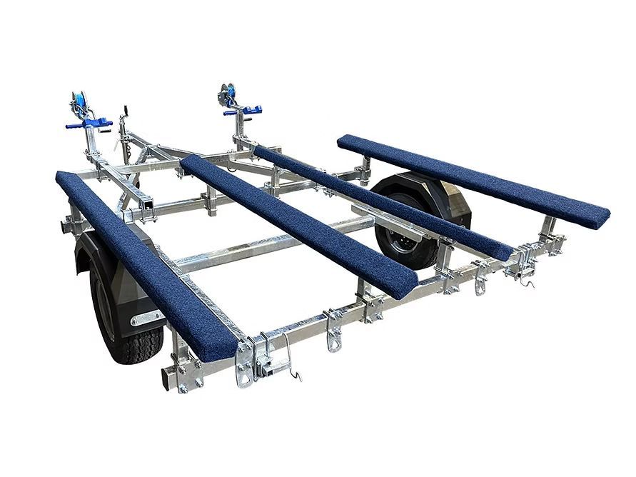 Boat trailer, galvanized steel frame with blue padded bunks and rollers, black tire.