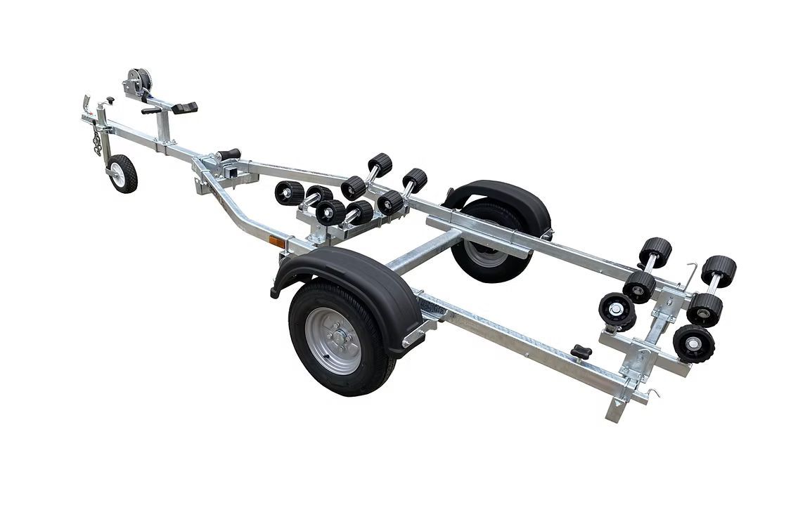 Galvanized boat trailer with multiple rollers, wheels, and a winch, isolated on white.