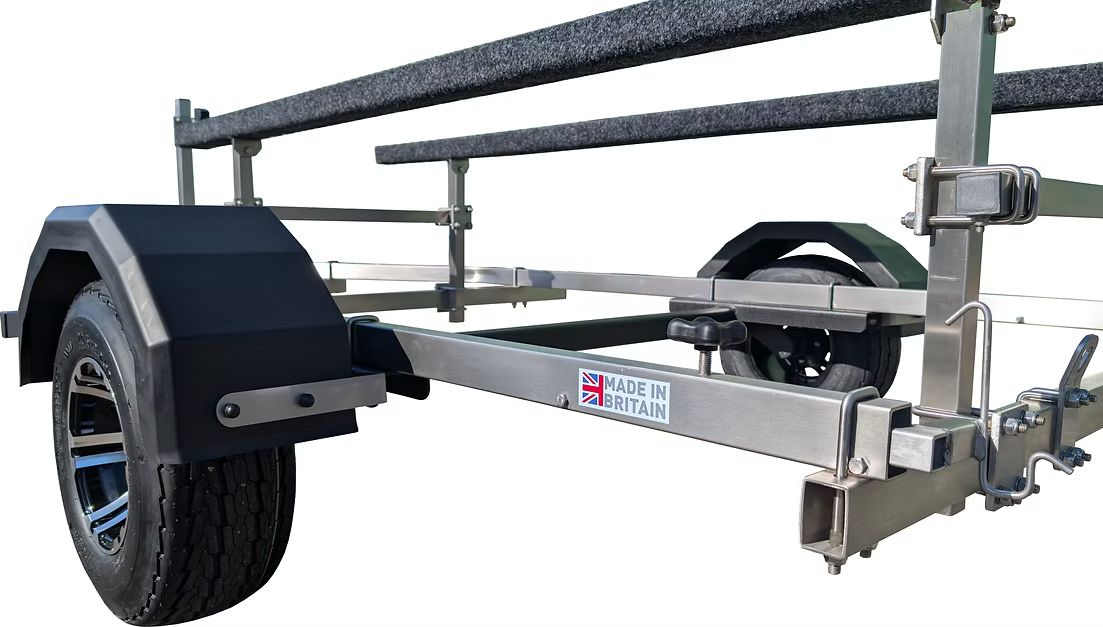 Boat trailer with two padded runners, black fenders, and wheels.