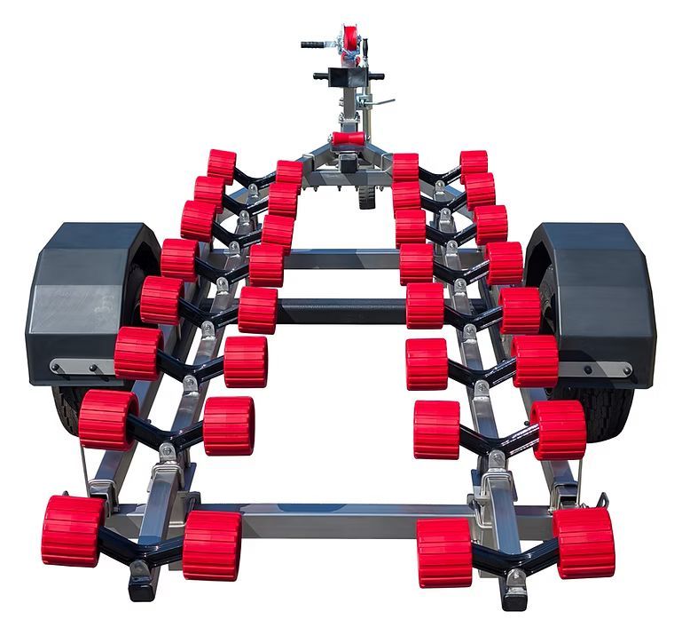 Boat trailer with red rollers, gray frame, and black fenders.