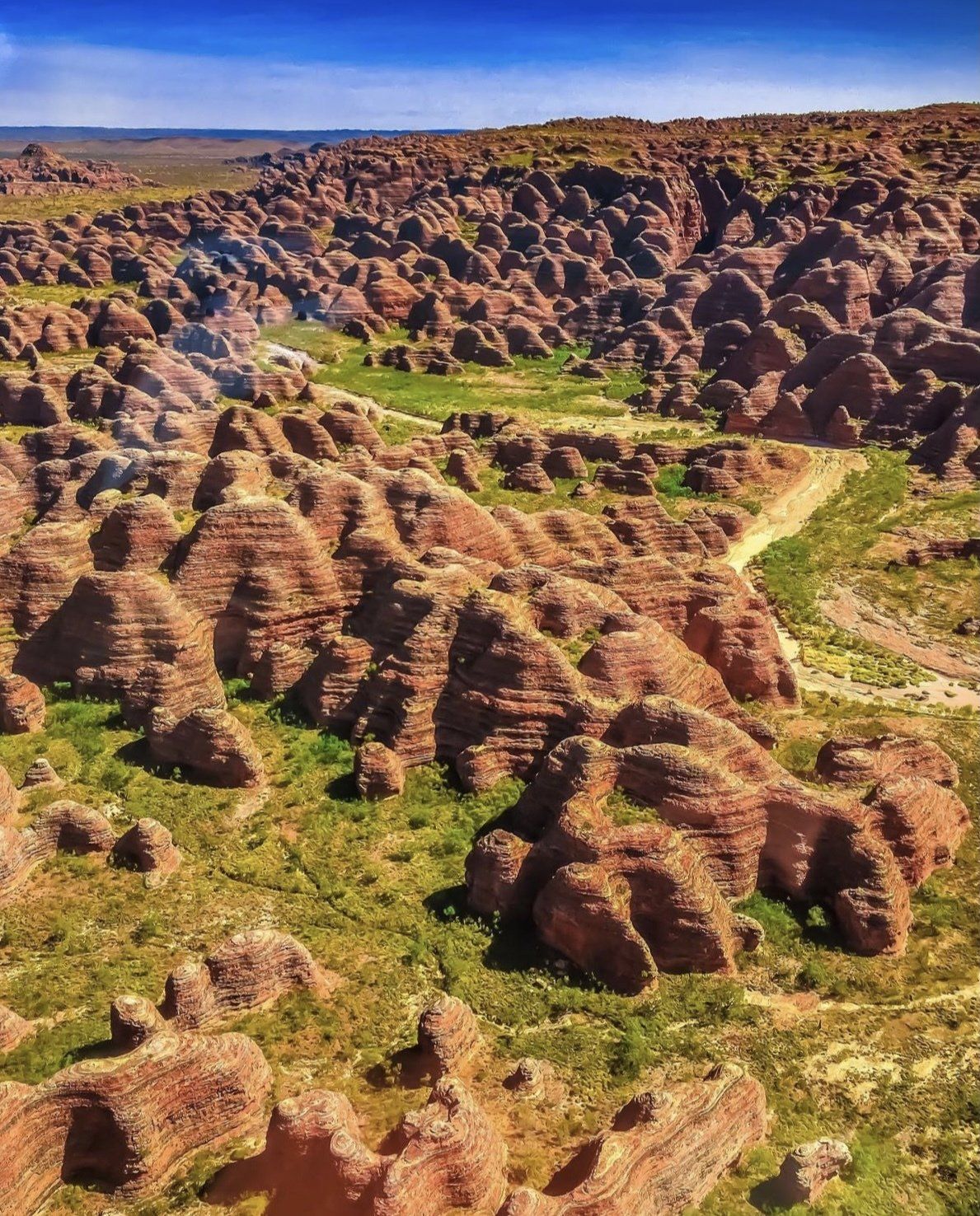 An aerial view of a rocky landscape with a road going through it.