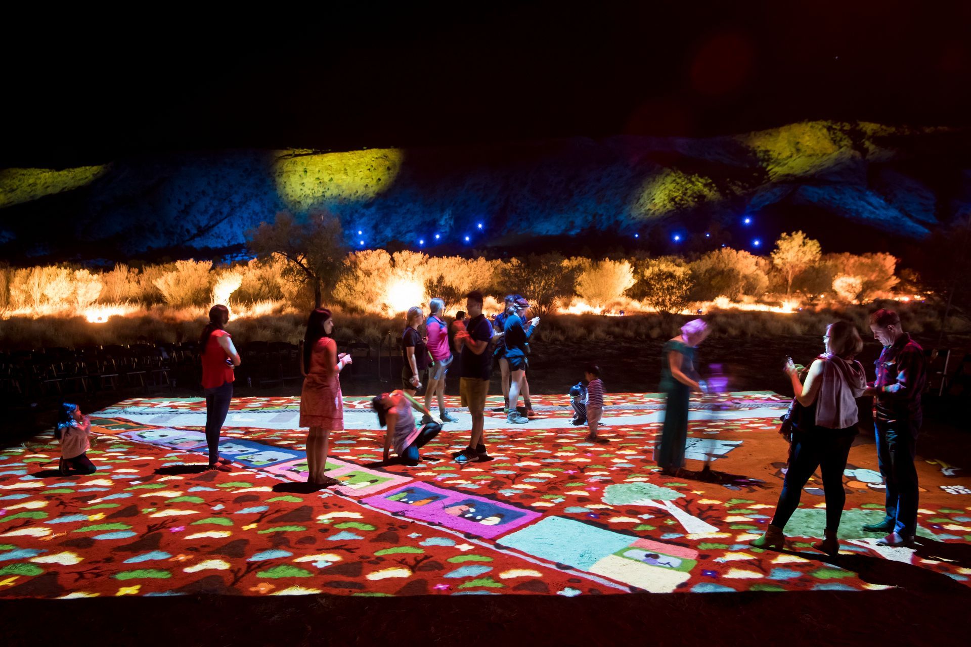 A group of people standing in front of a colorful display