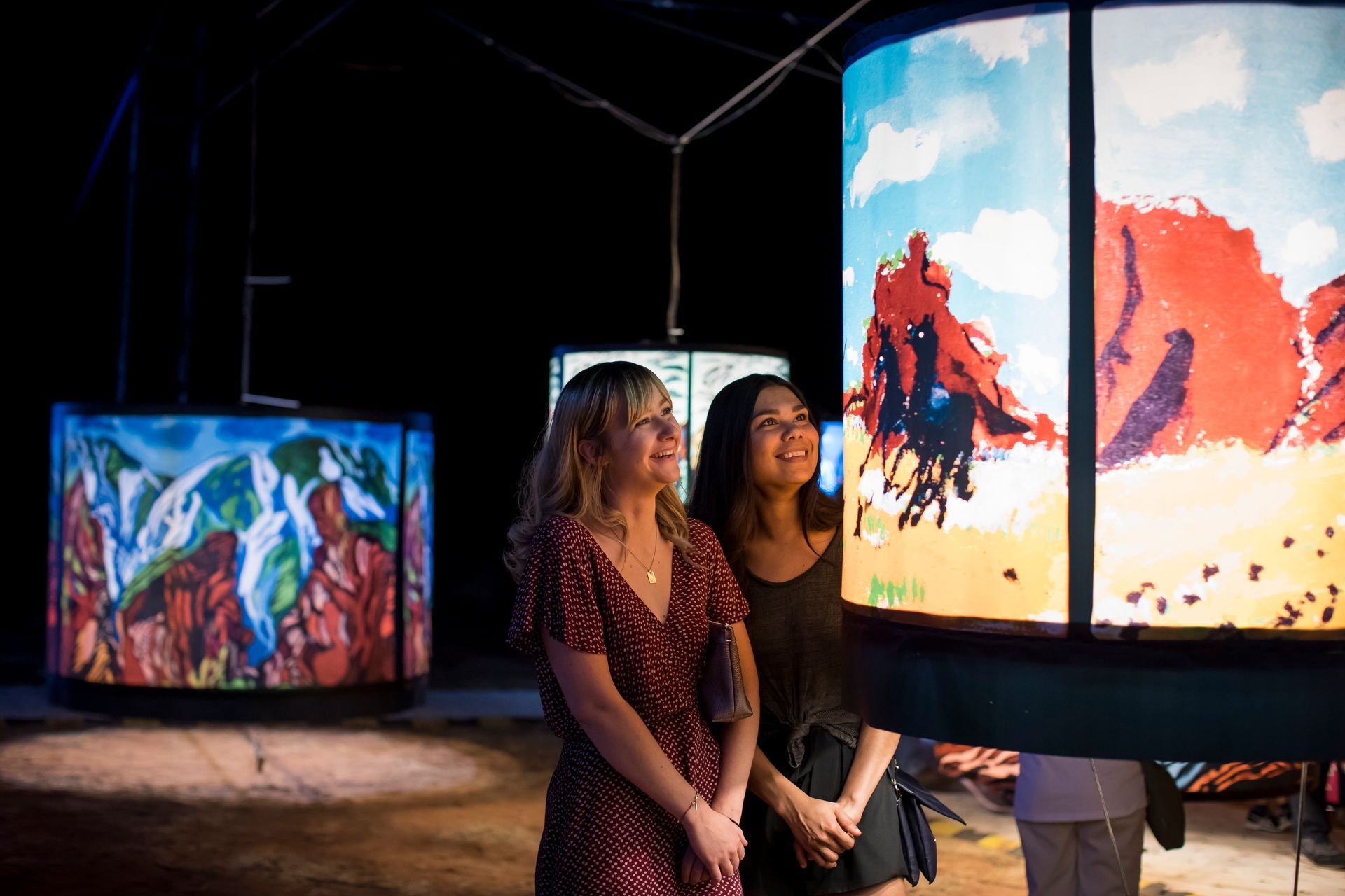 Two women are looking at a painting in a museum.