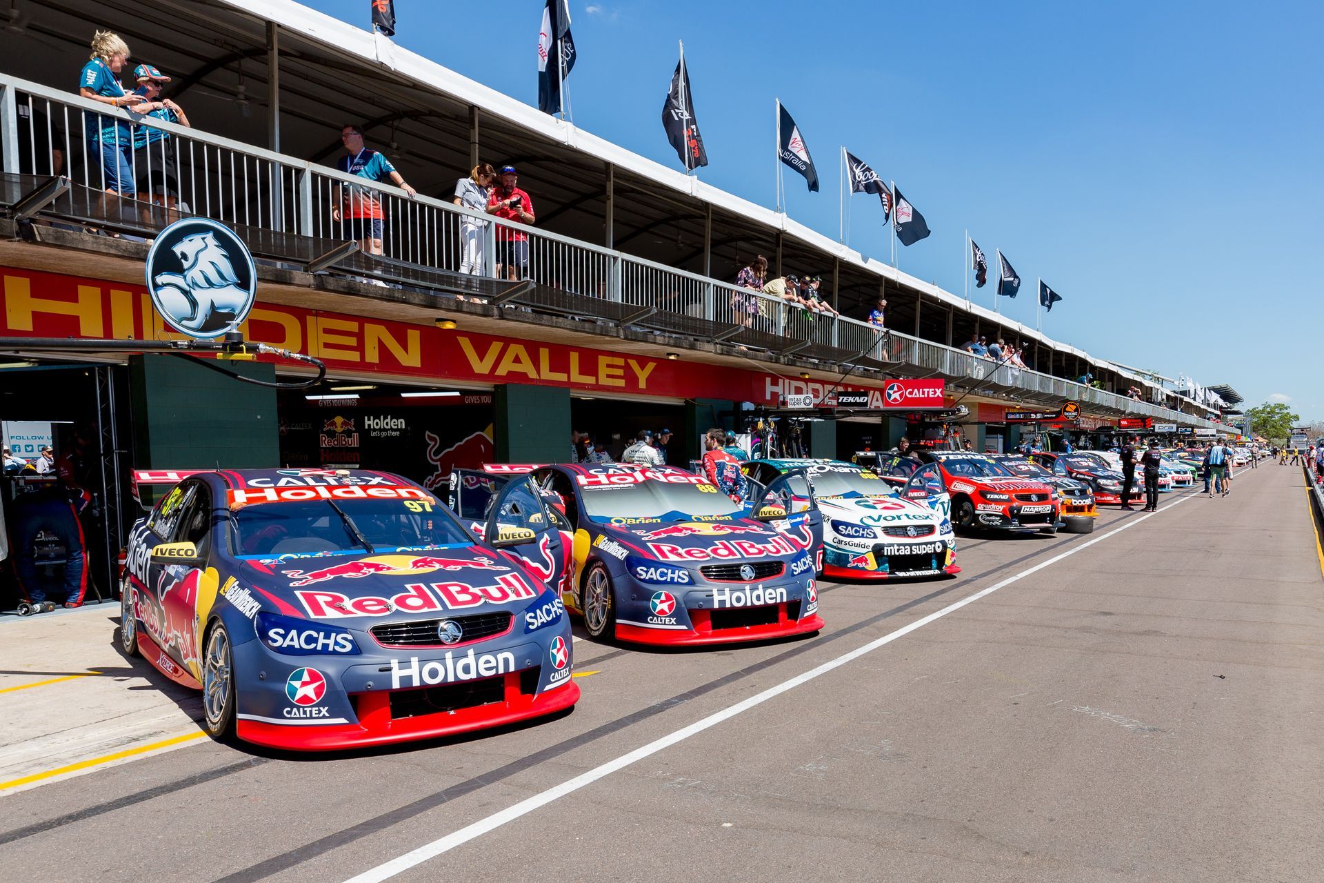 A row of race cars are parked in front of a building that says holden valley