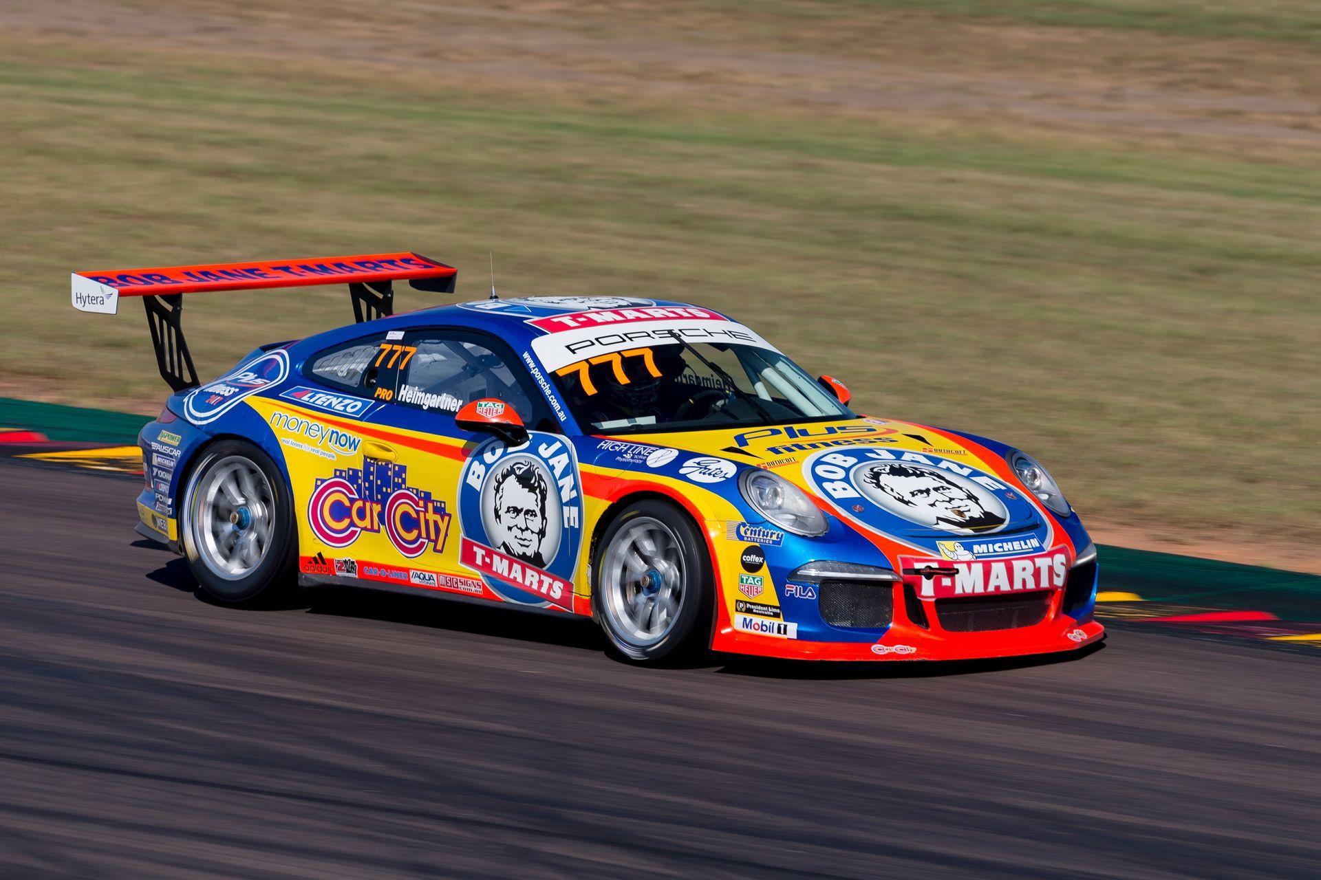 A colorful race car is driving down a race track.