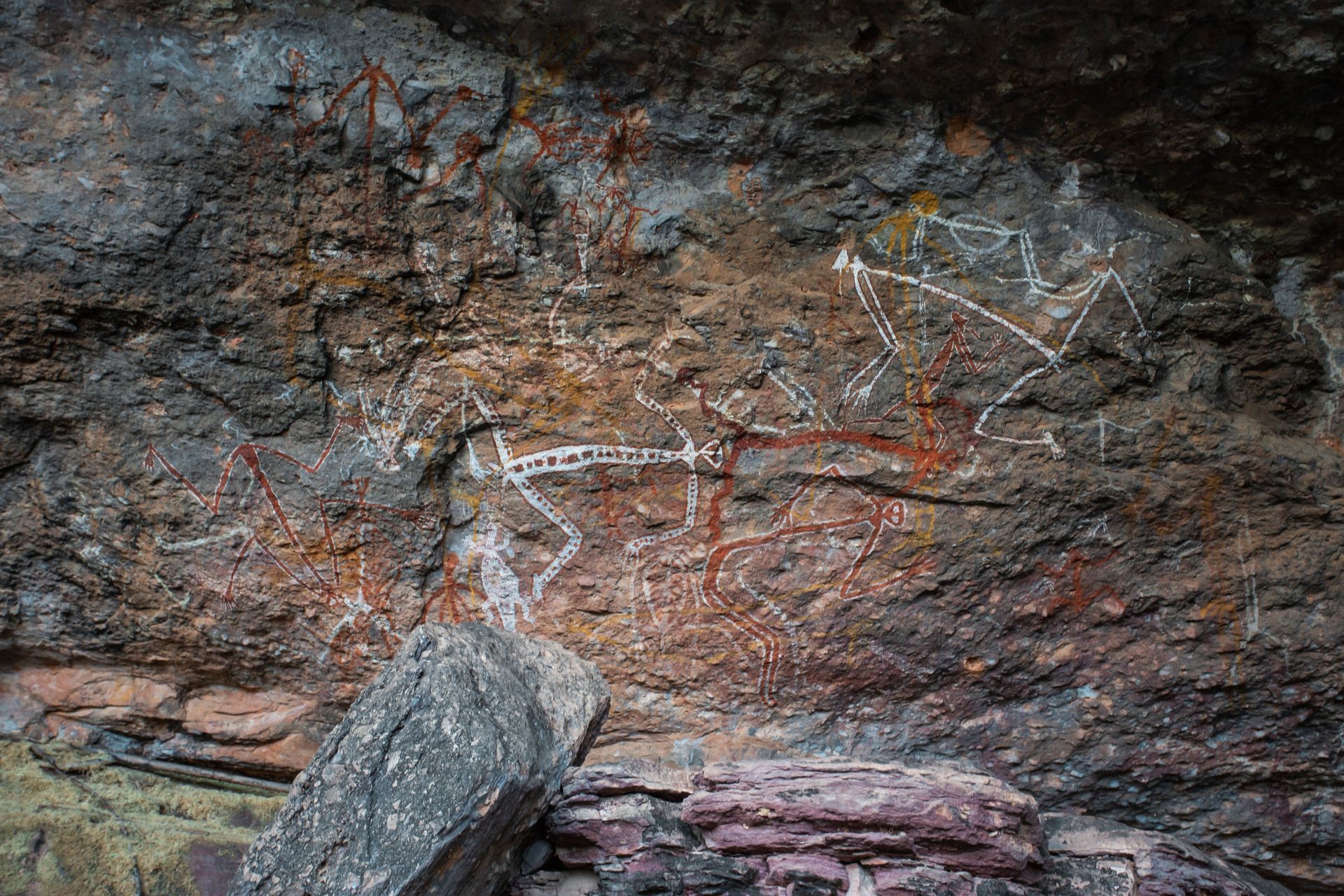 A close up of a rock wall with a painting on it.