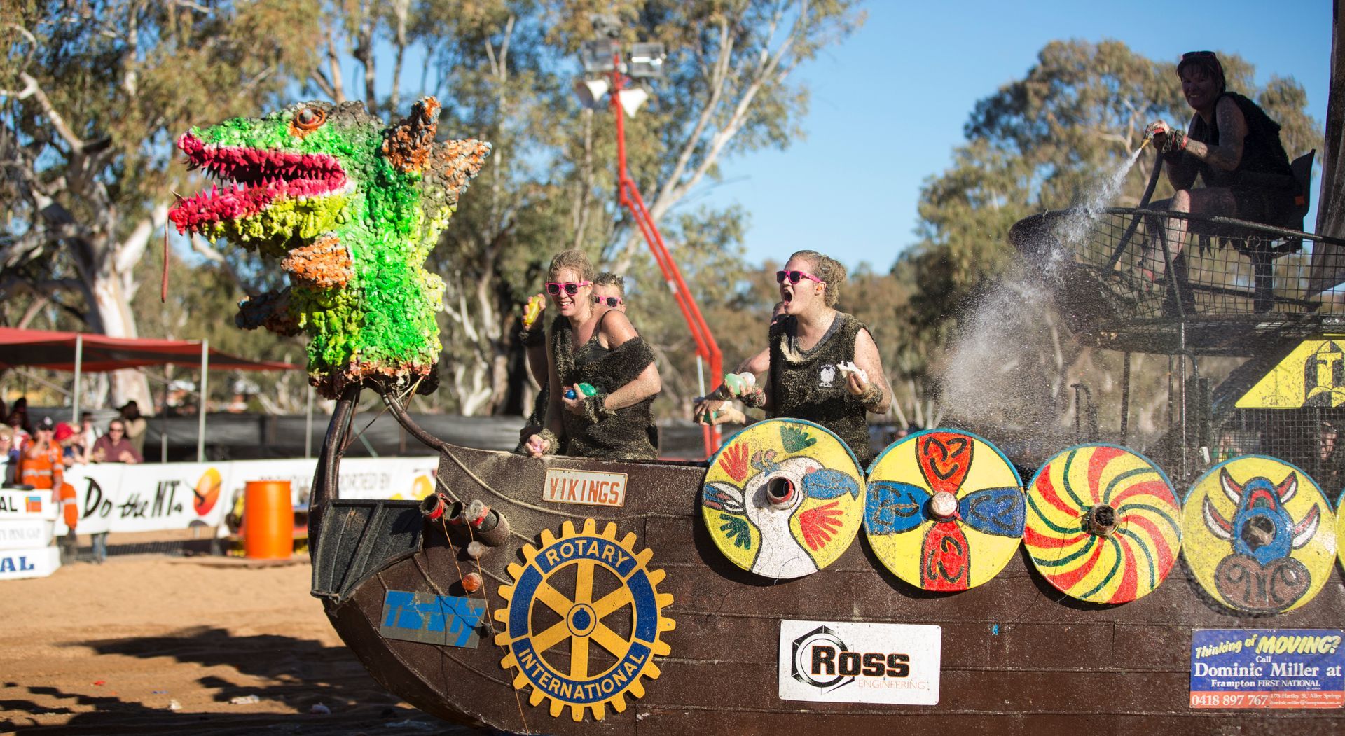 A group of people are sitting on top of a colorful vehicle.