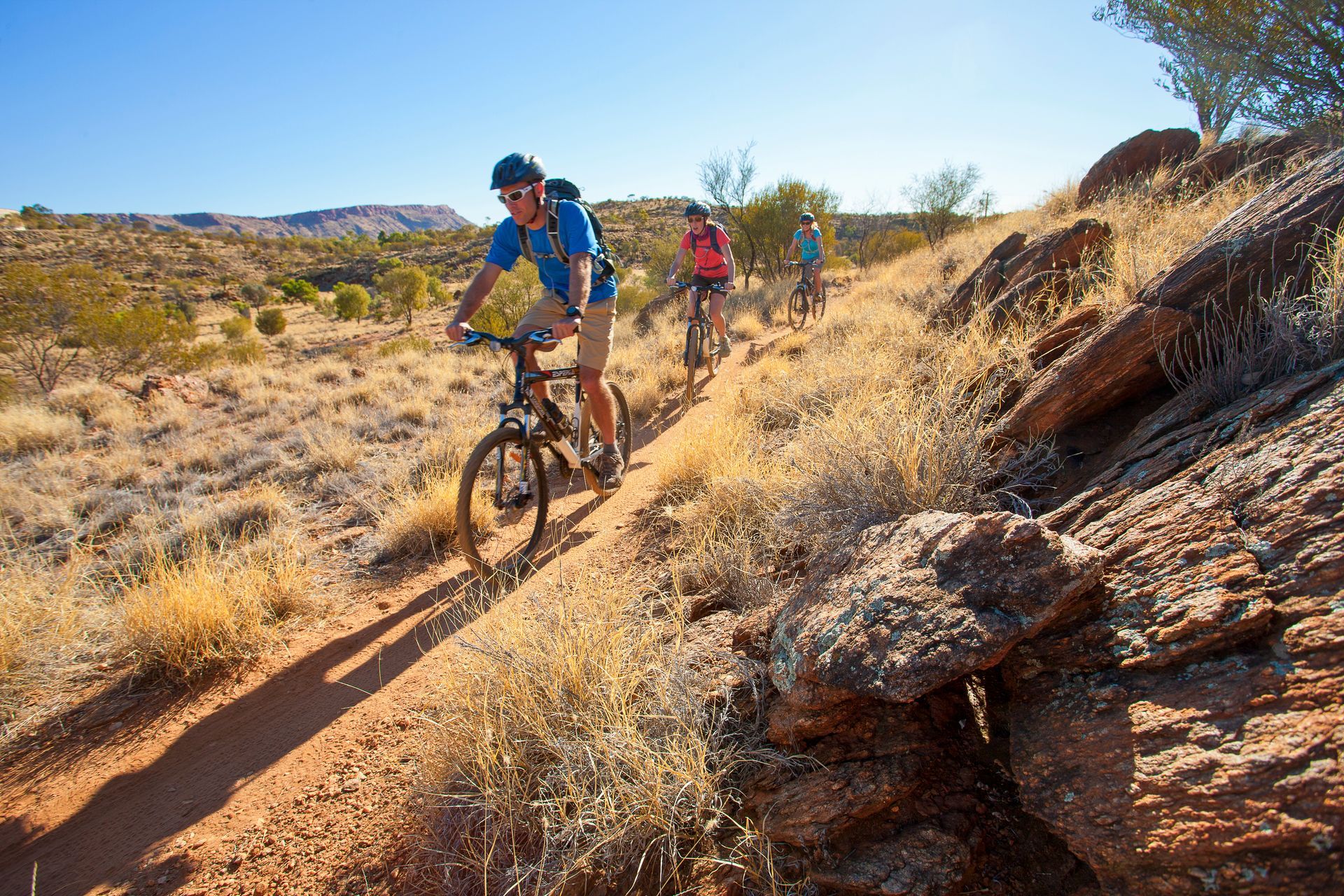 A group of people are riding bikes down a dirt trail.