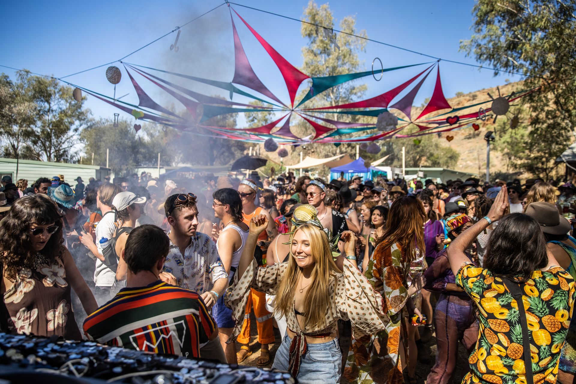 A large group of people are dancing at a festival.