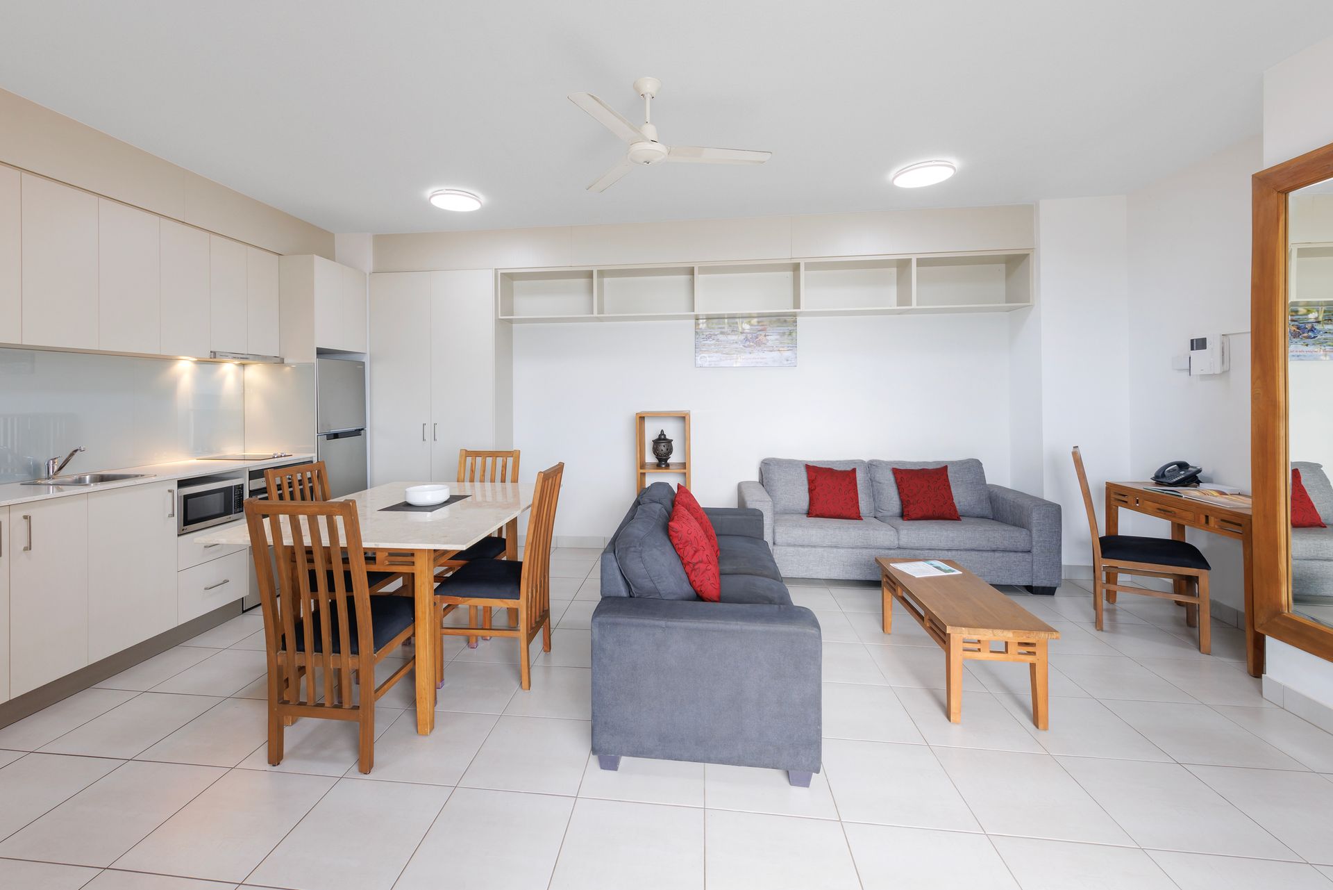 A hotel room with a king size bed , desk , chair and television.