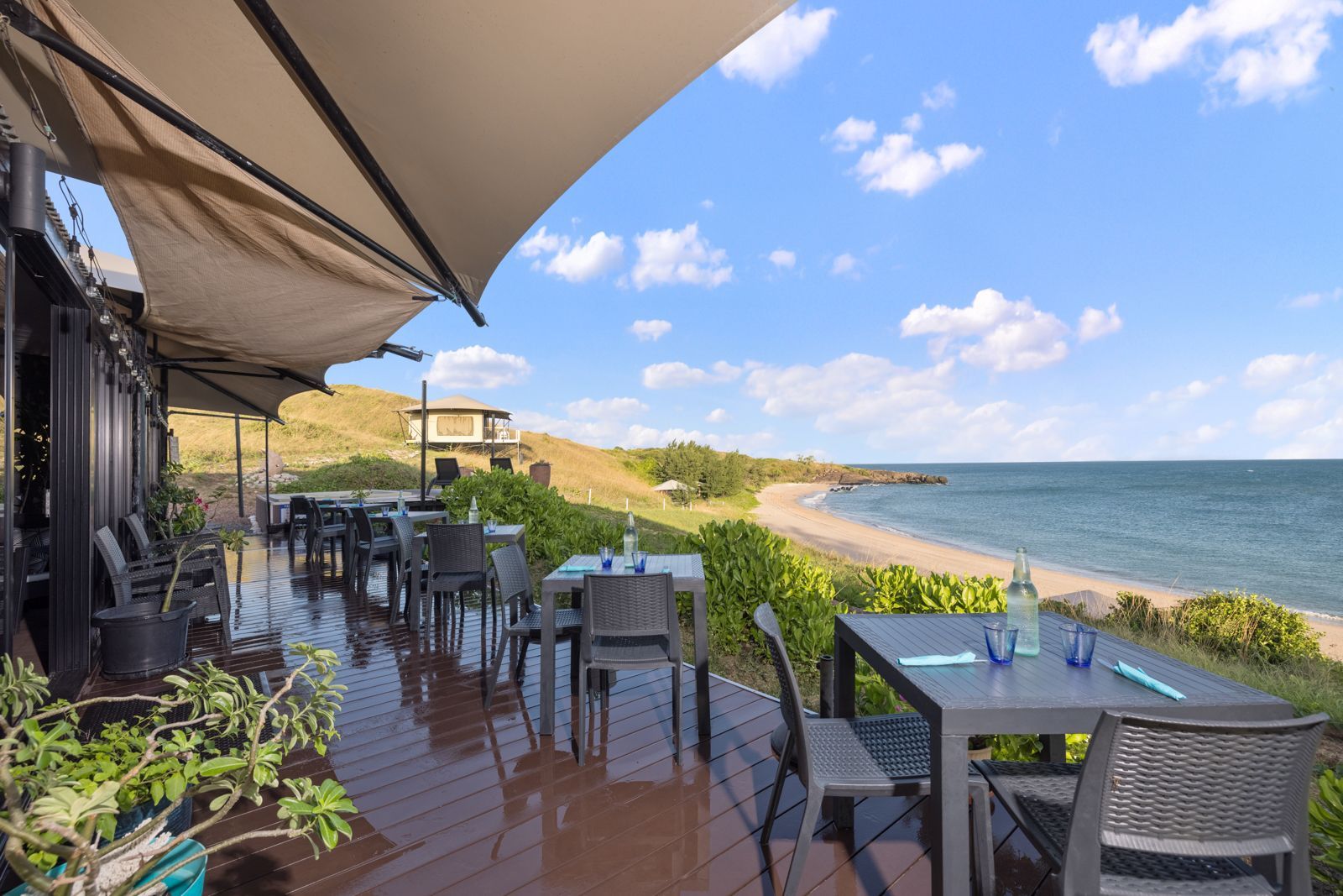A restaurant with tables and chairs overlooking the ocean