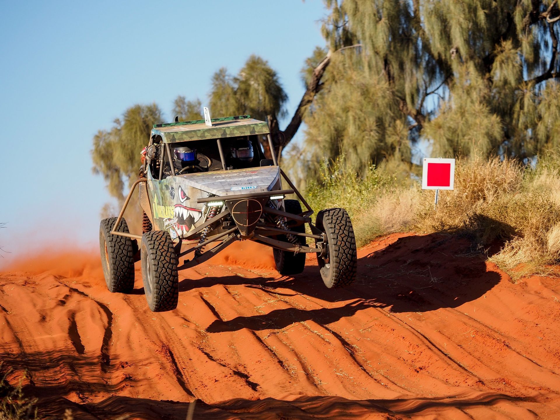 A buggy is driving down a dirt road.
