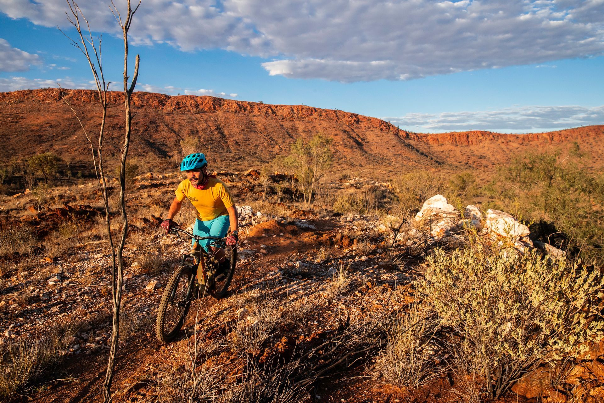 A man is riding a bike on a trail in the desert.