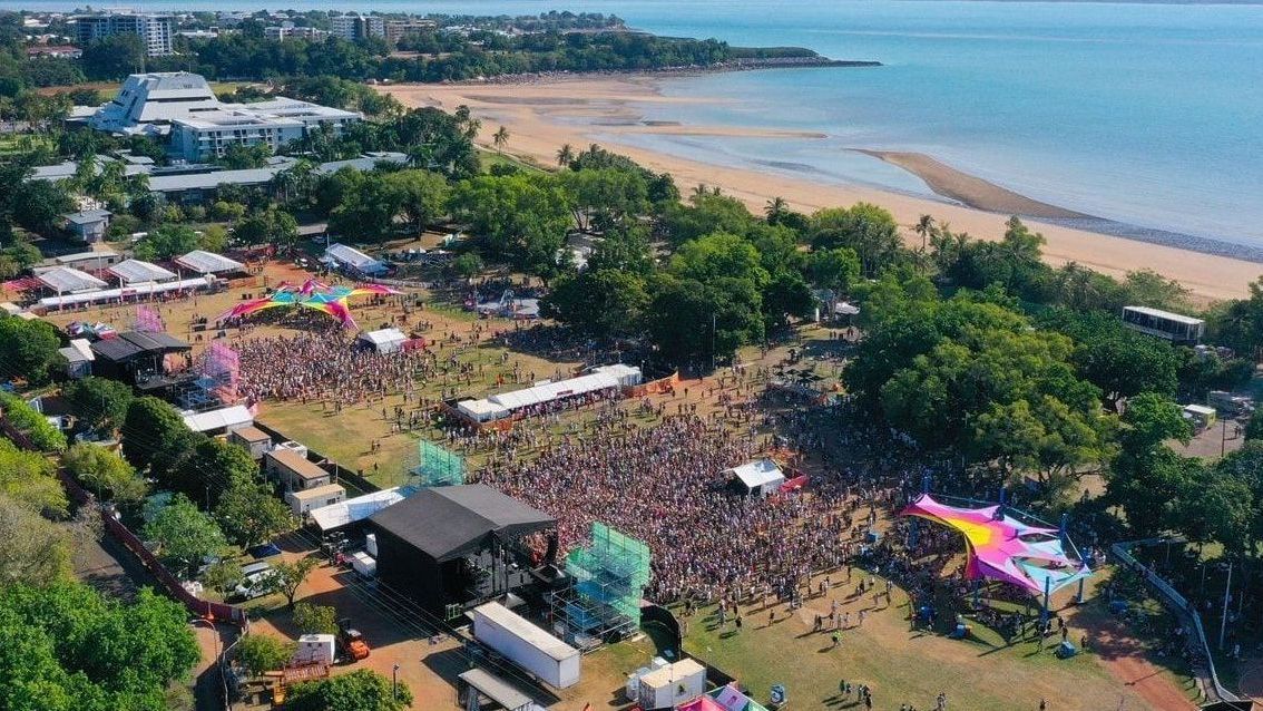 An aerial view of a large crowd of people at a music festival.