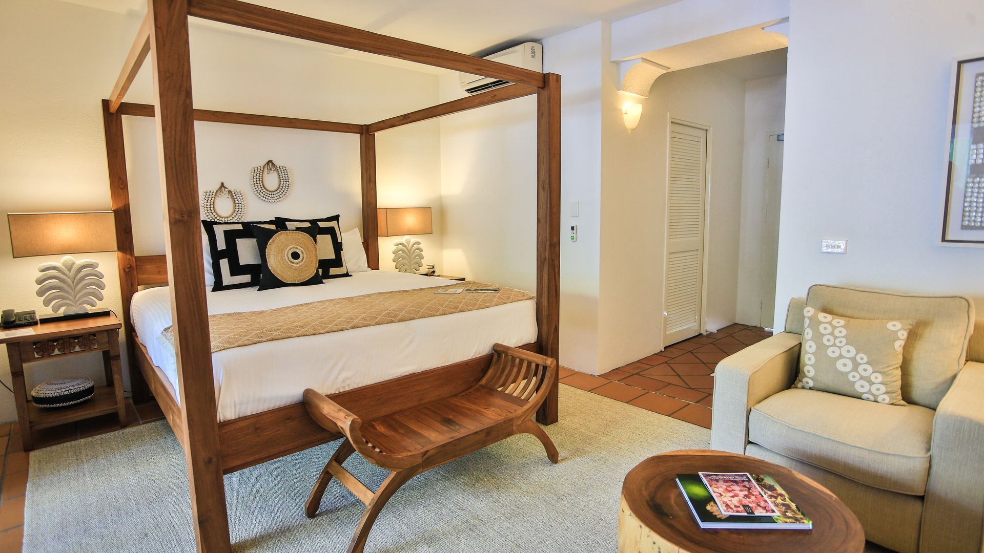 A group of people are sitting at tables on a roof overlooking a body of water.