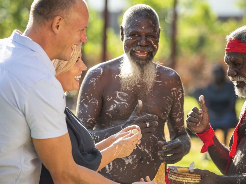 A group of people are standing around a man with a beard.