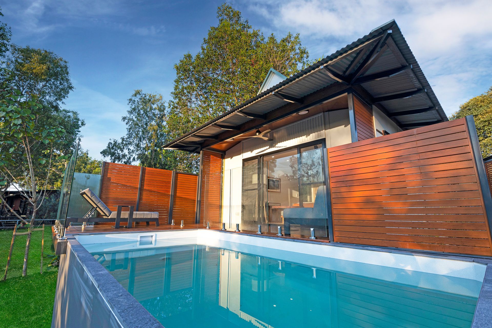 A small house with a swimming pool in front of it.
