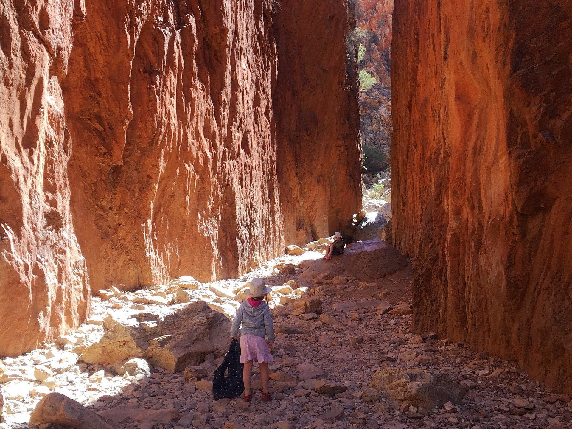 A person standing in a canyon between two rock walls