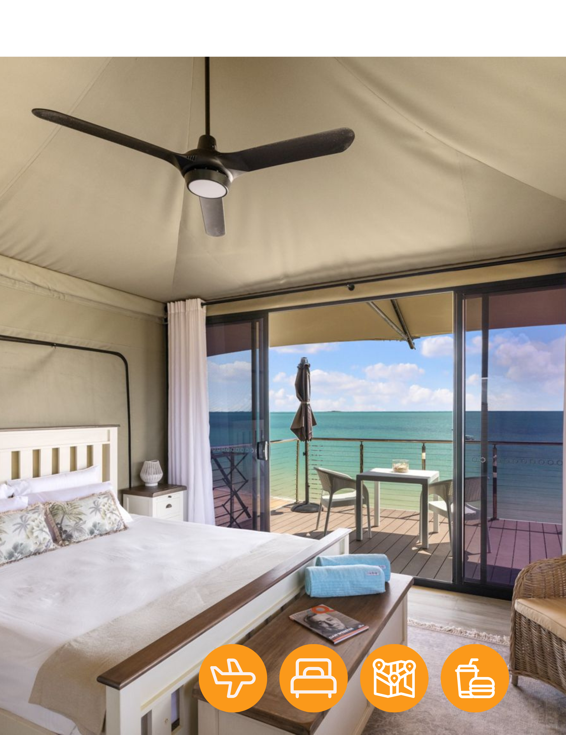 A bedroom with a ceiling fan and a view of the ocean