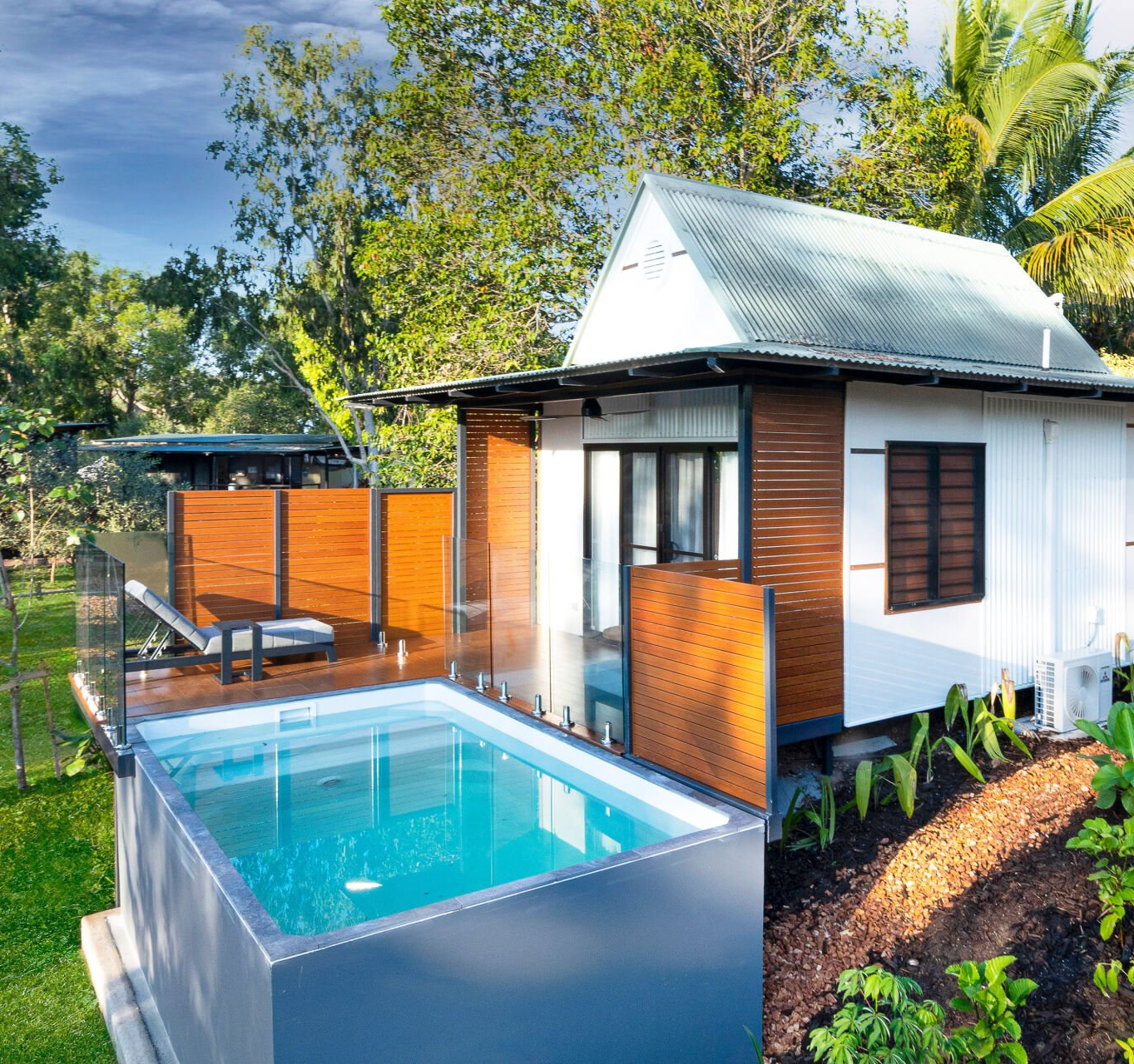 A small house with a swimming pool in front of it