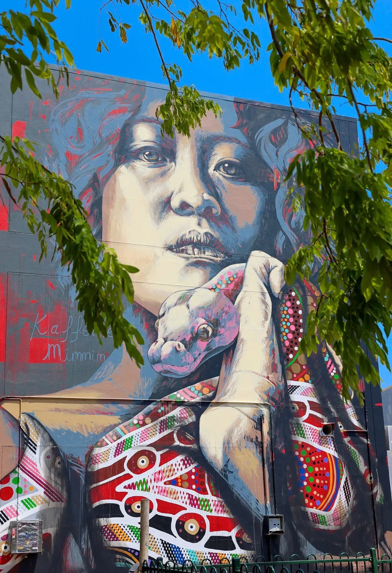 A large mural of a woman holding a donut on the side of a building.