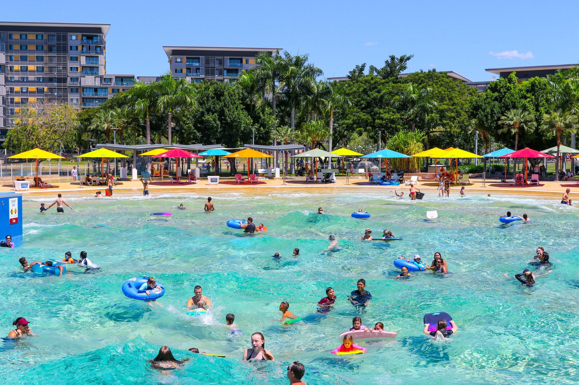 A large group of people are swimming in a large swimming pool.