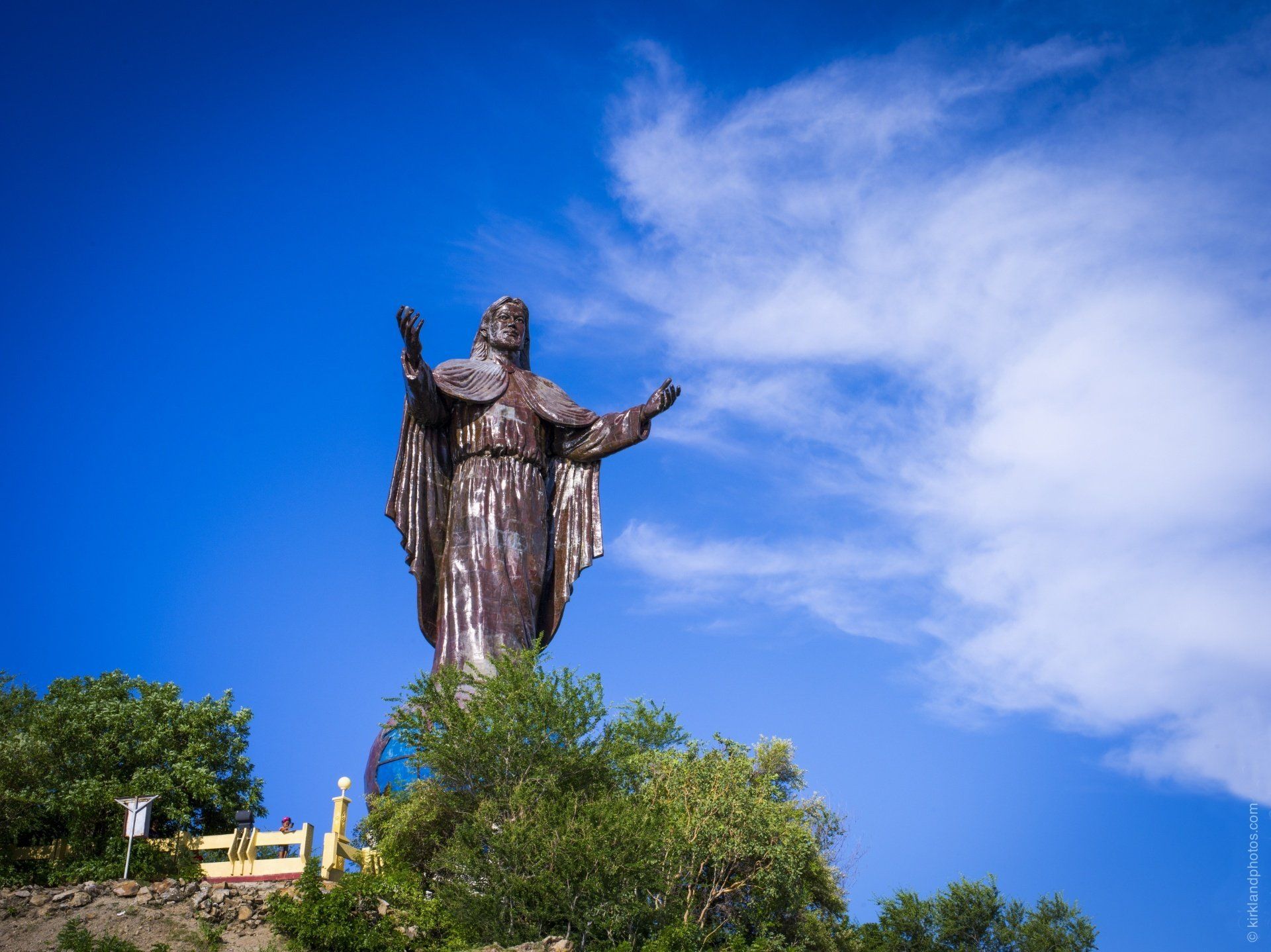 A large statue of jesus standing on top of a hill