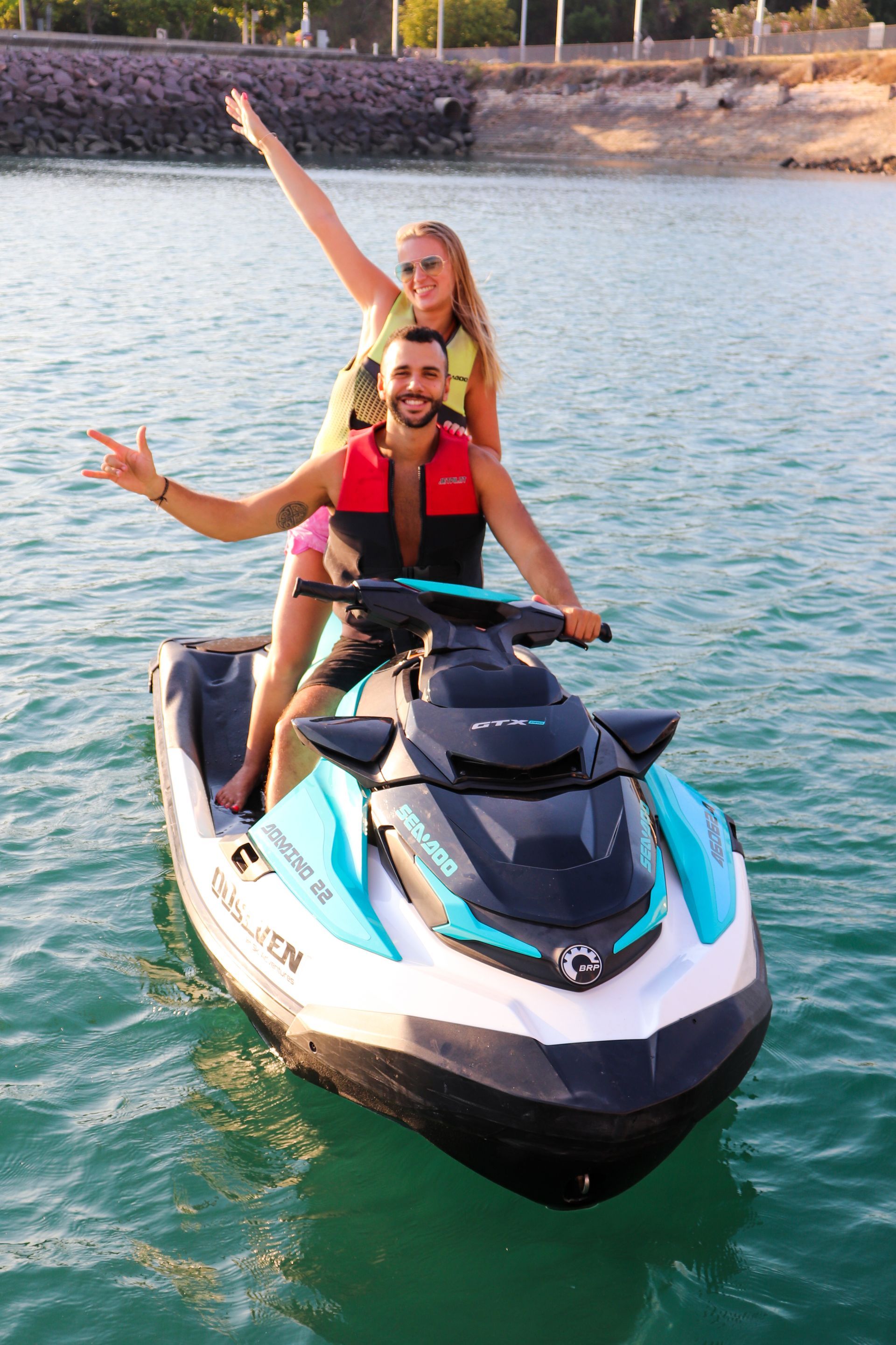 A man and a woman are riding a jet ski in the water.