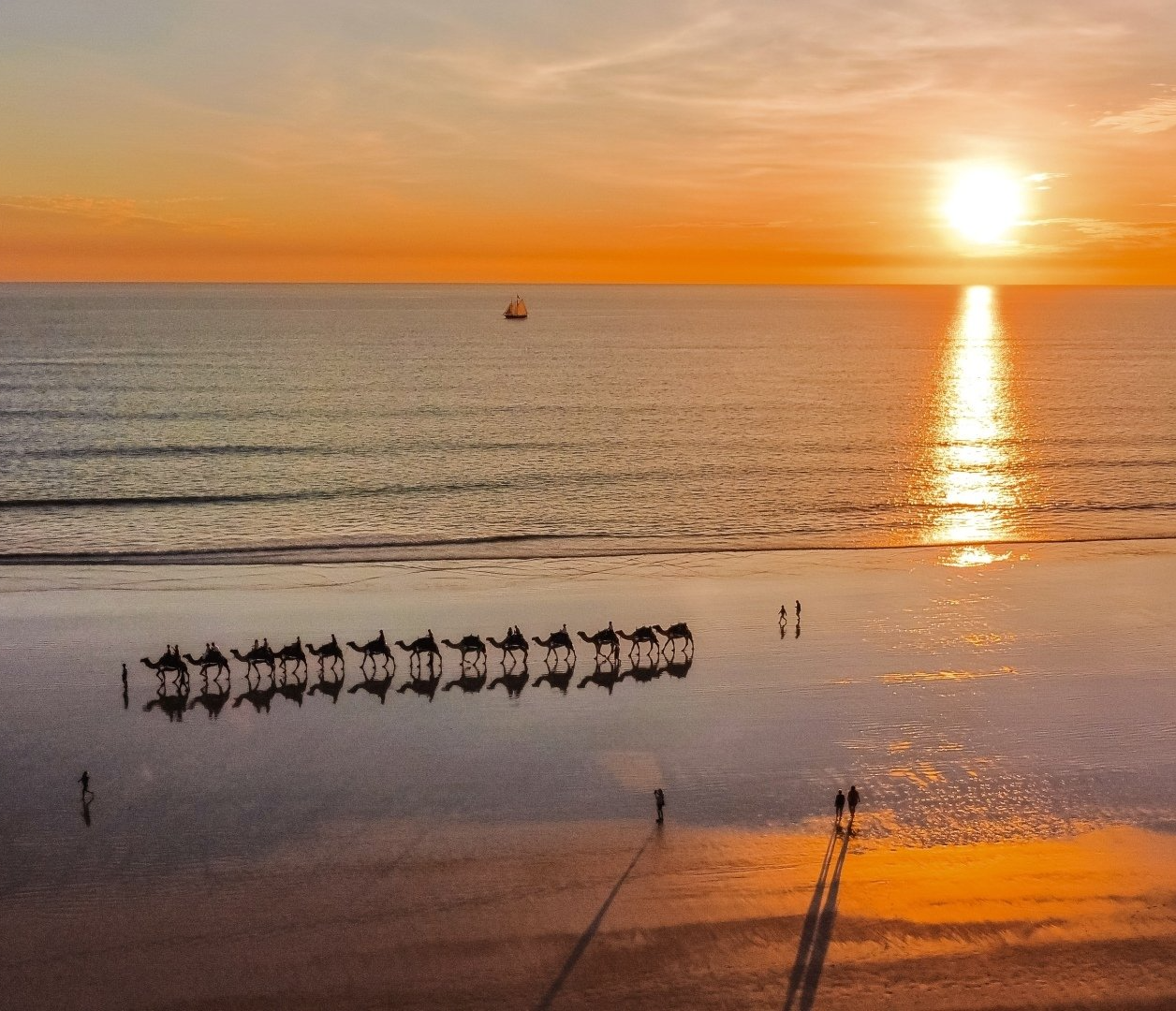 A sunset over the ocean with a boat in the distance