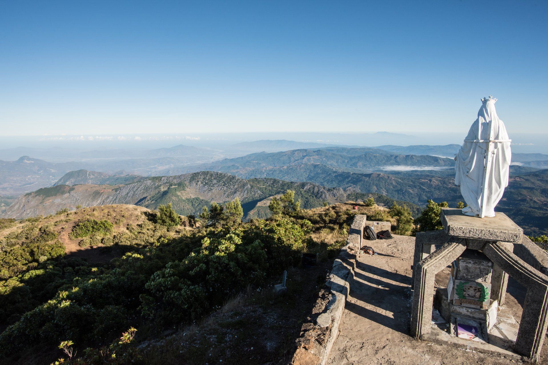 There is a statue of jesus on top of a mountain.