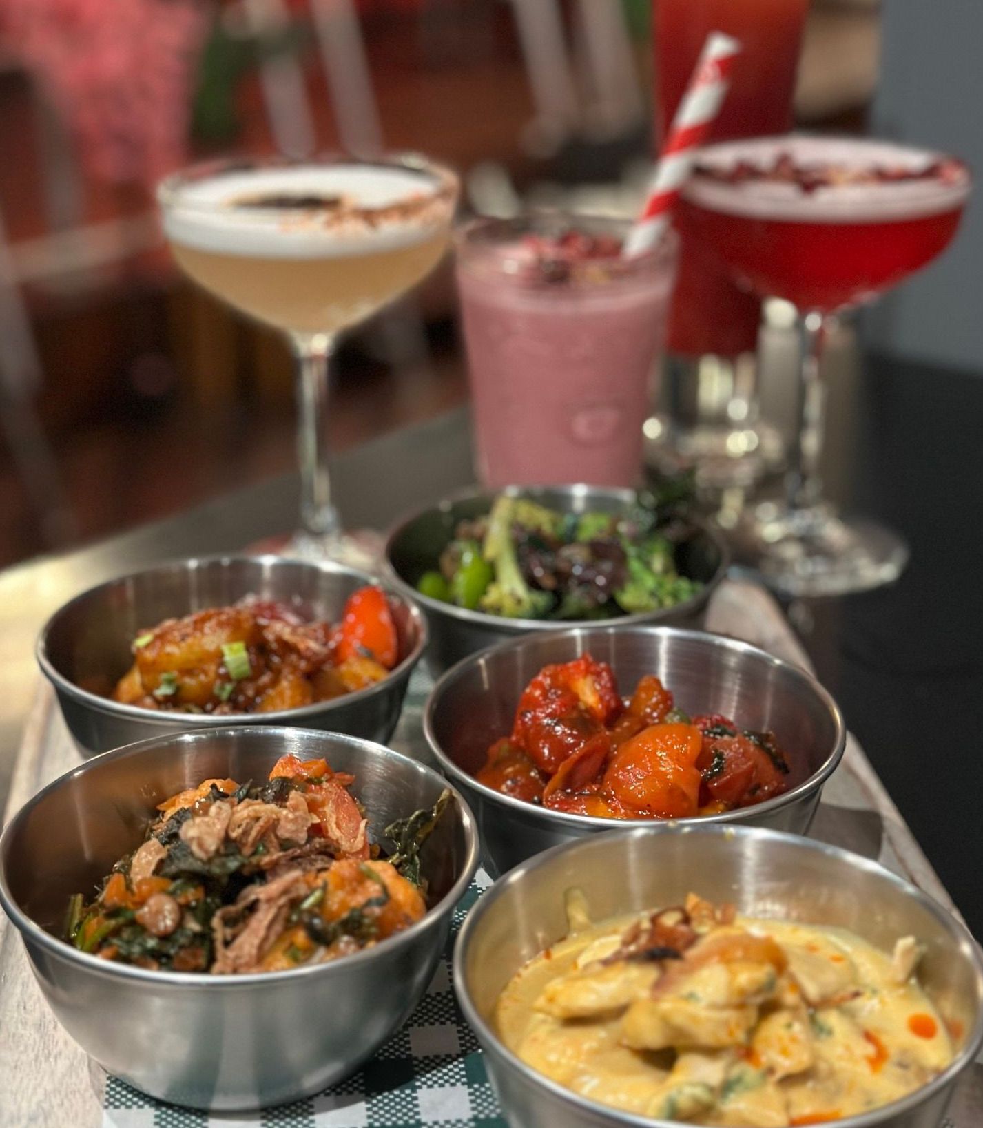 A tray of food with a martini in the background