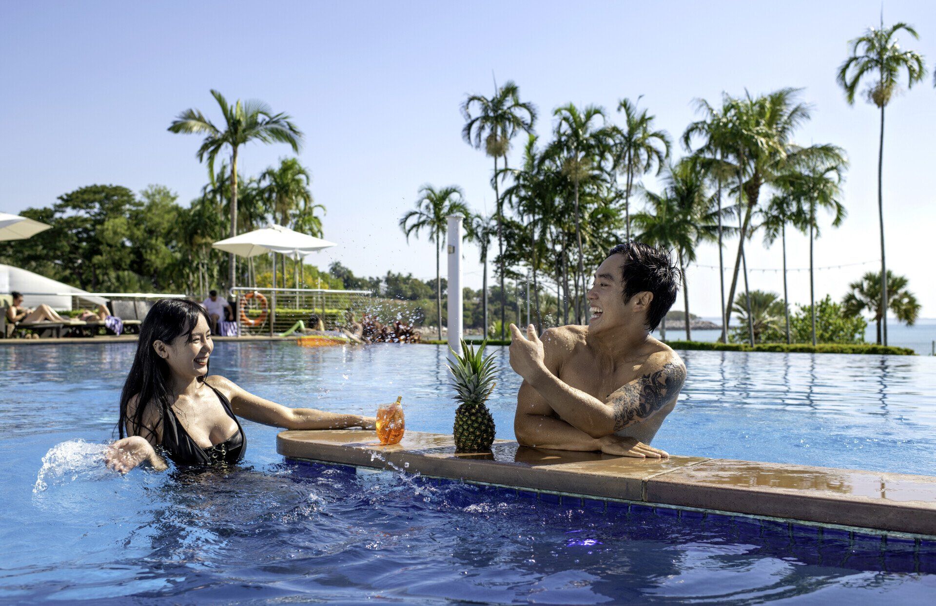 A man and a woman are sitting at a bar in a swimming pool.