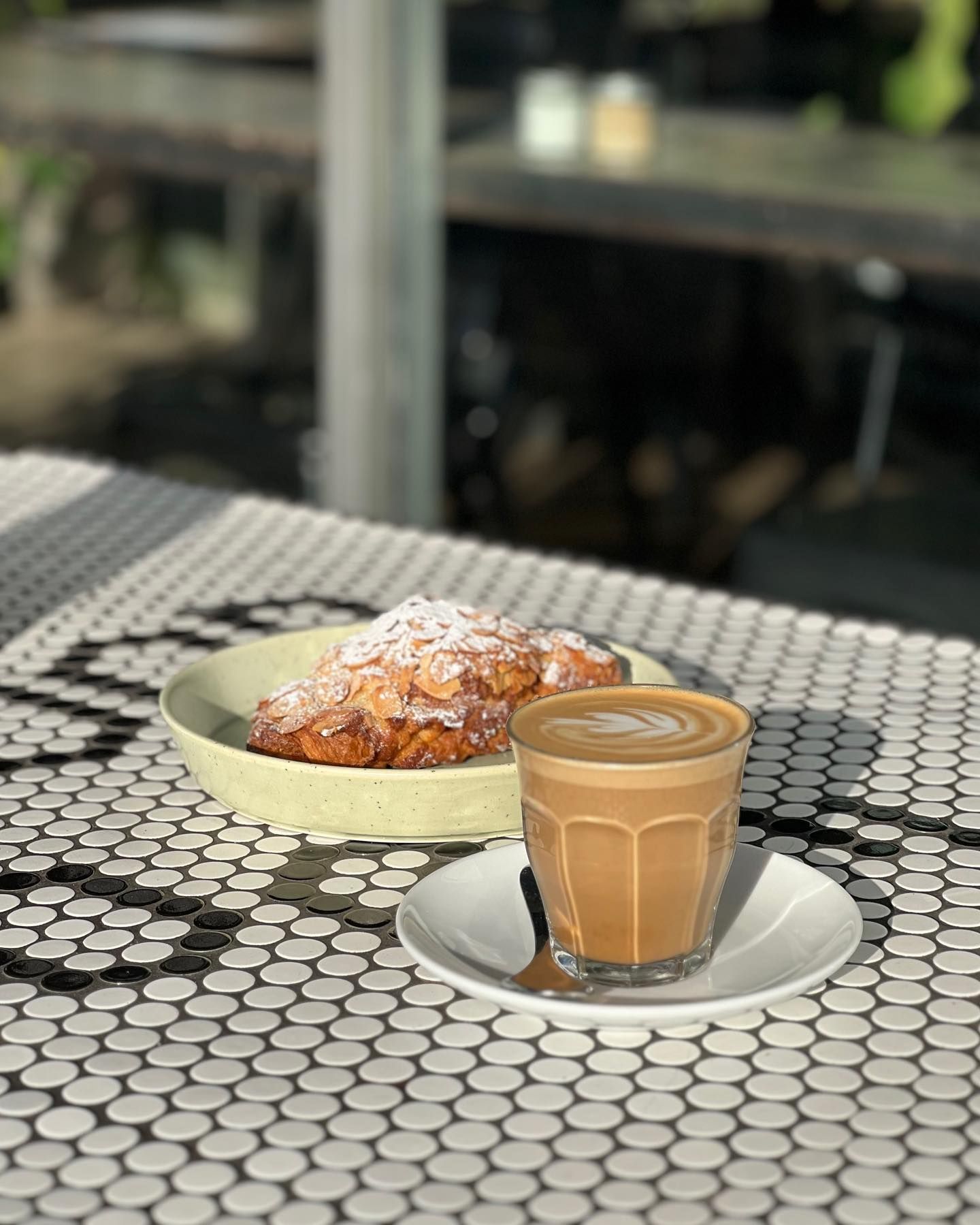 A cup of coffee and a plate of food on a table.