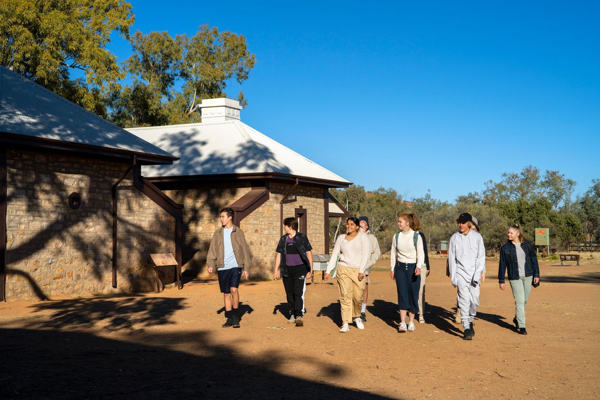 A group of people are walking in front of a building.