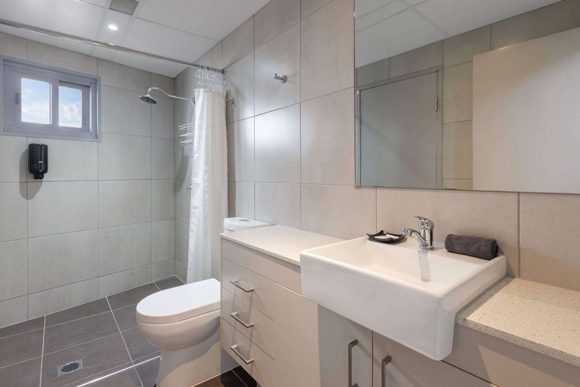 A living room with a couch , coffee table , and kitchen.