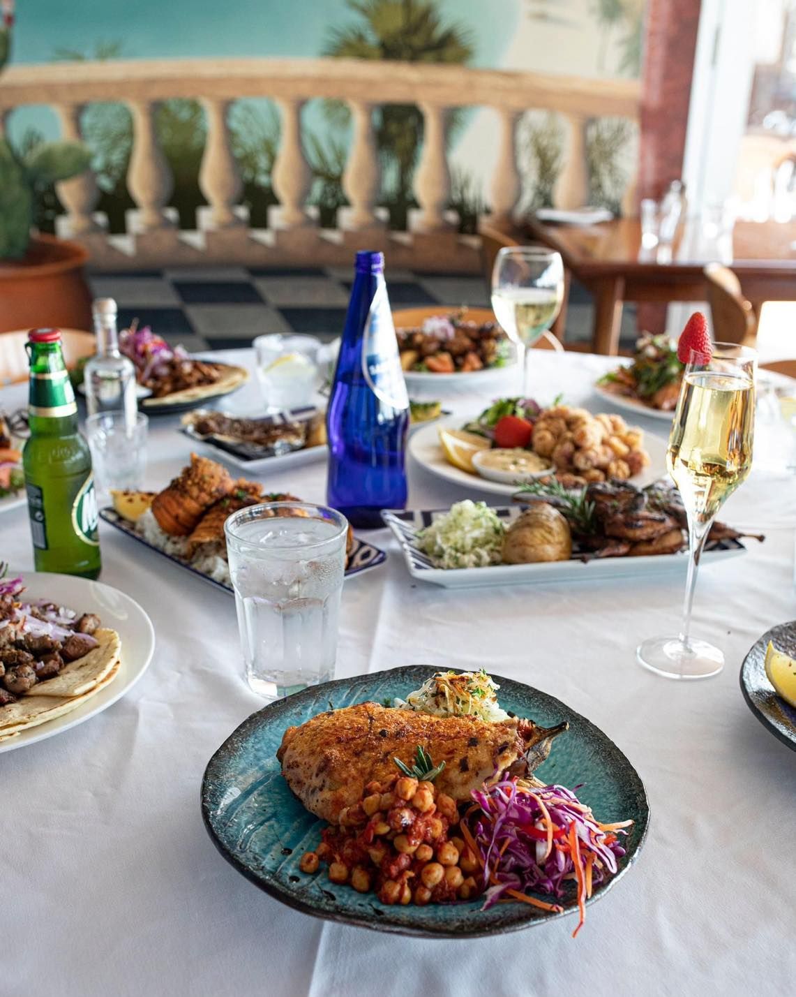 A table topped with plates of food and wine glasses