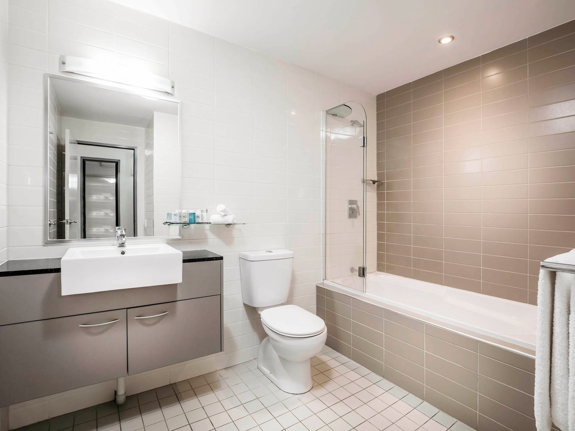 A bathroom with a toilet , sink , and bathtub.