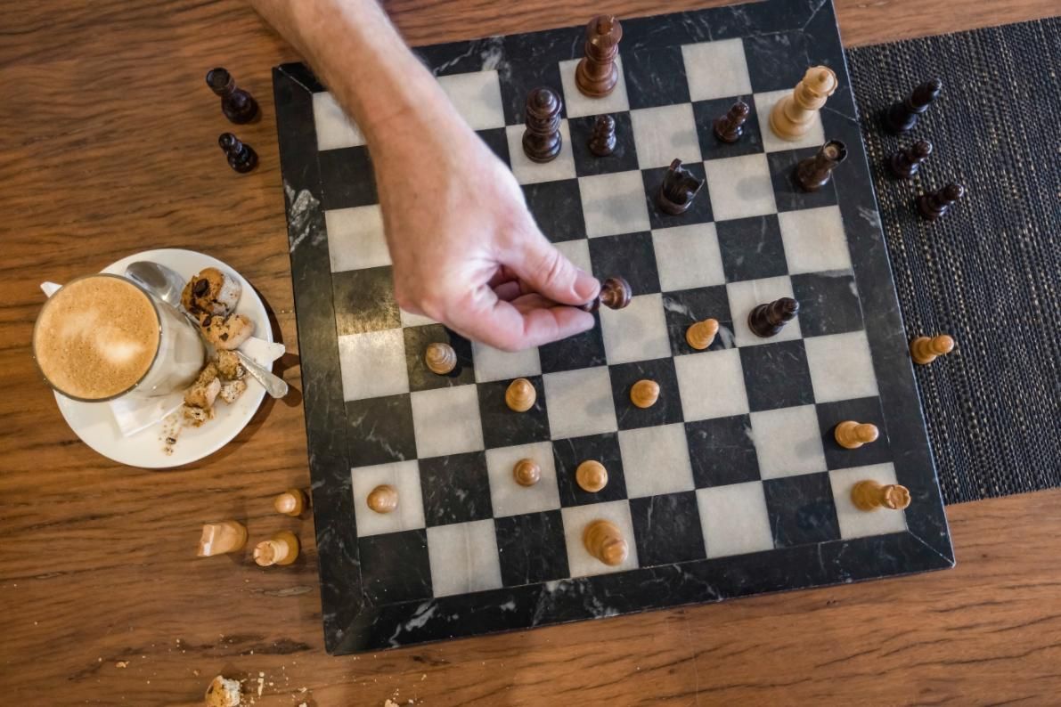 A living room with a couch , table , chairs and a ceiling fan.