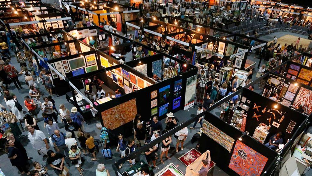 An aerial view of a large convention center filled with people.