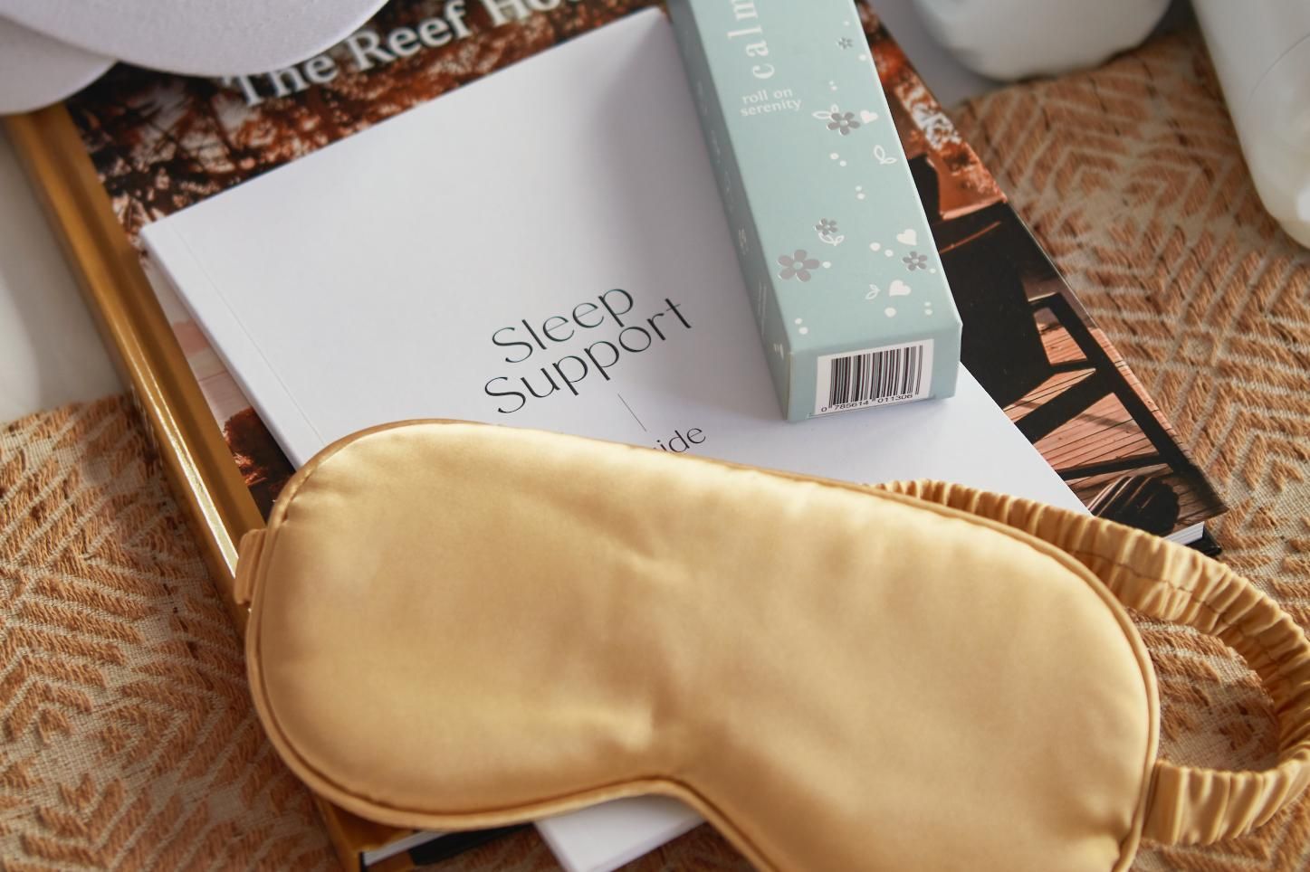 A living room with a couch , table , refrigerator and kitchen.