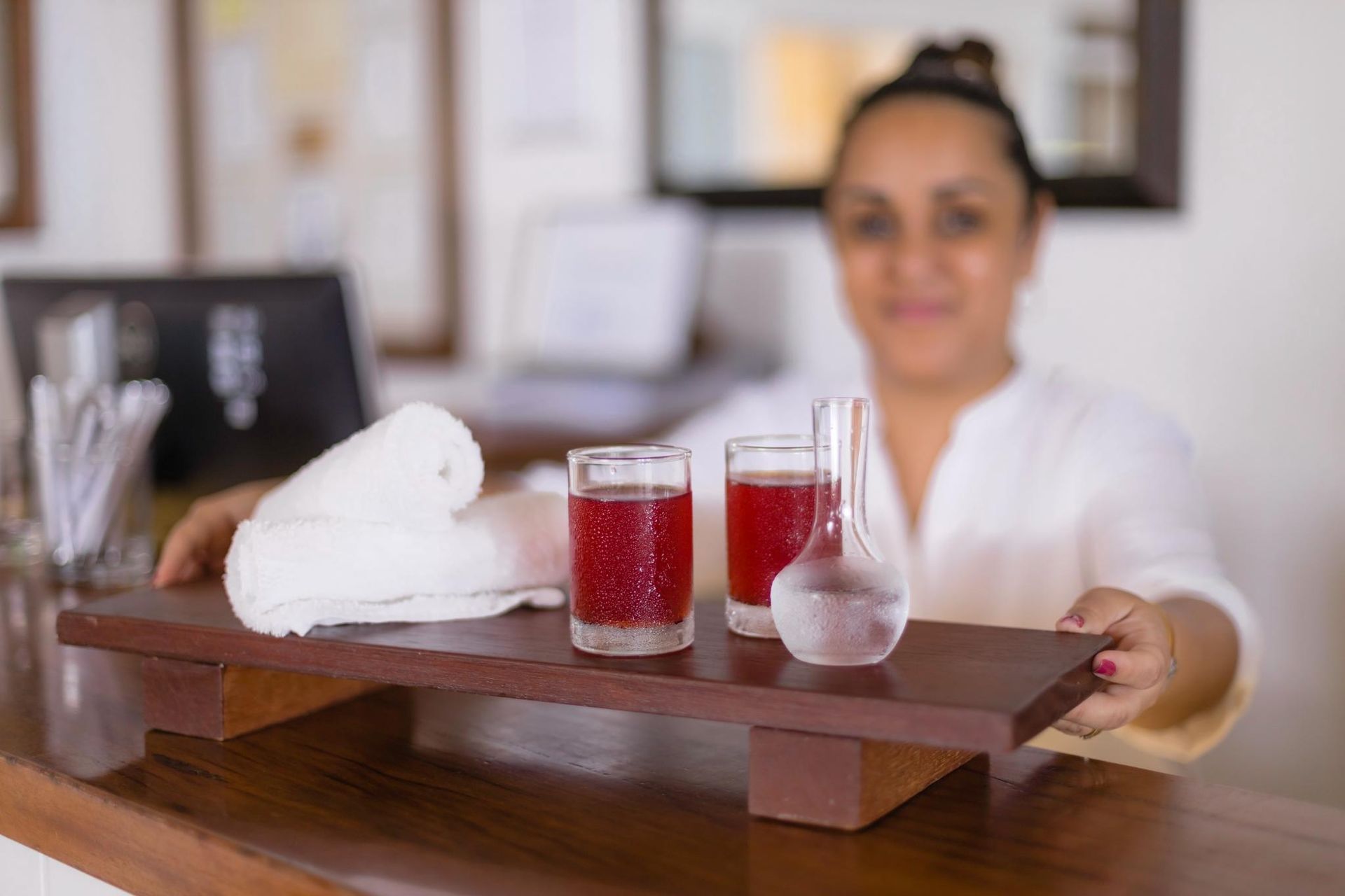 A living room with a couch , table , refrigerator and kitchen.