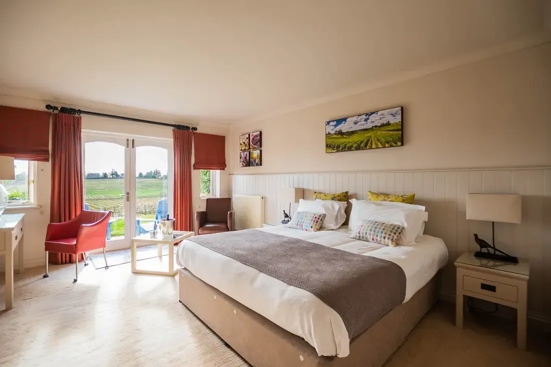 a hotel room with a large bed and a chair
