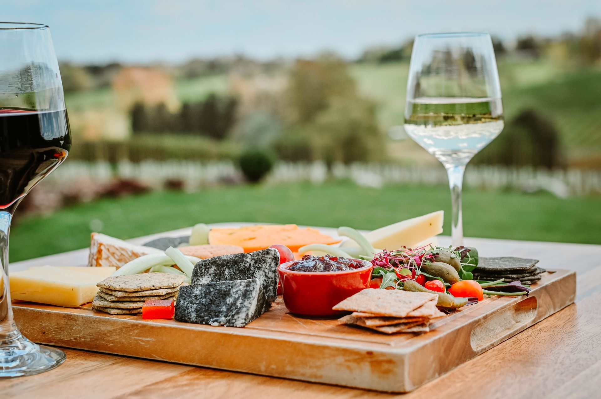 A glass of wine ready for tasting and a charcuterie board for grazing at Three Choirs Vineyards