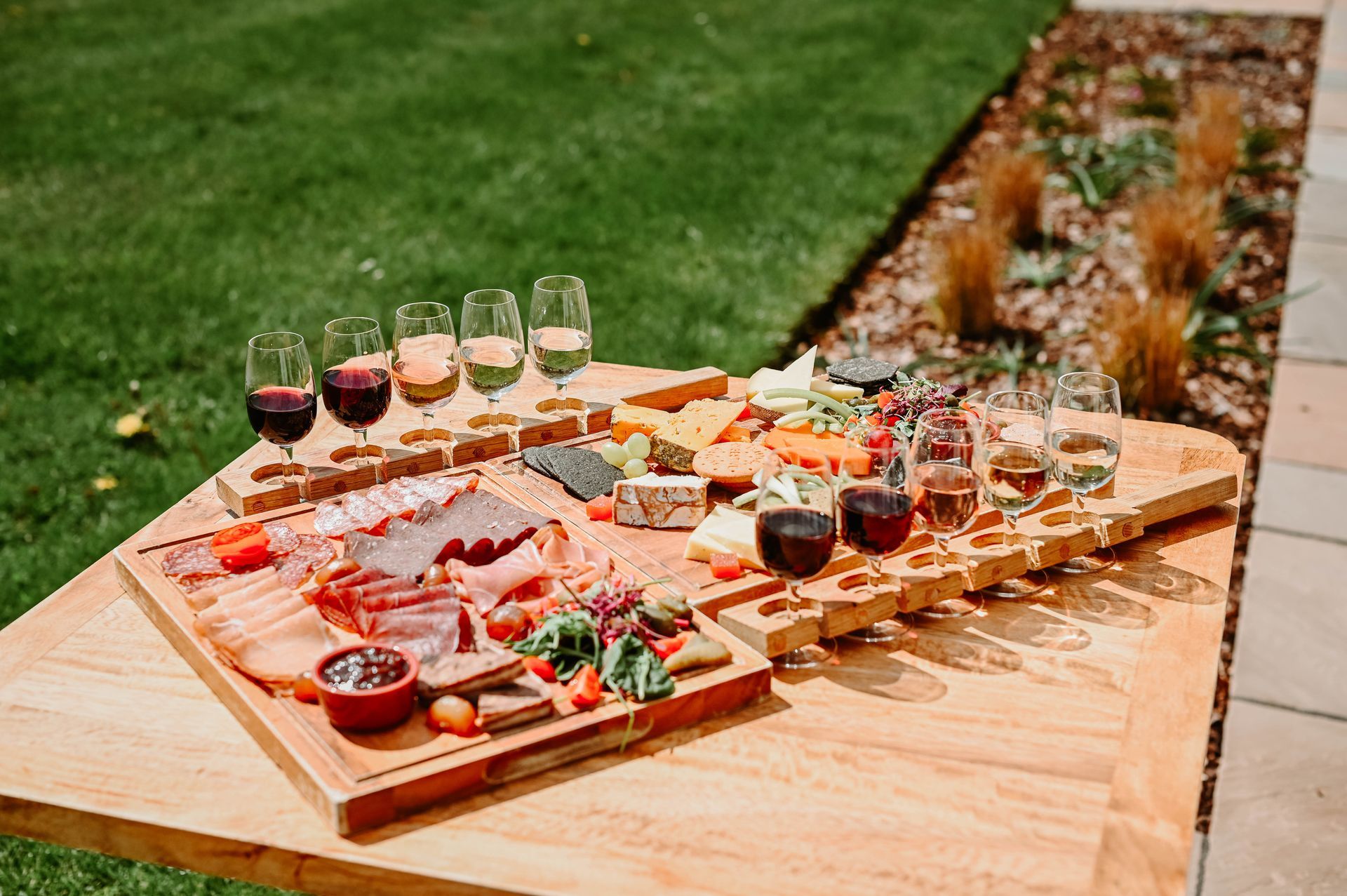 a wooden table topped with a variety of food and wine glasses .
