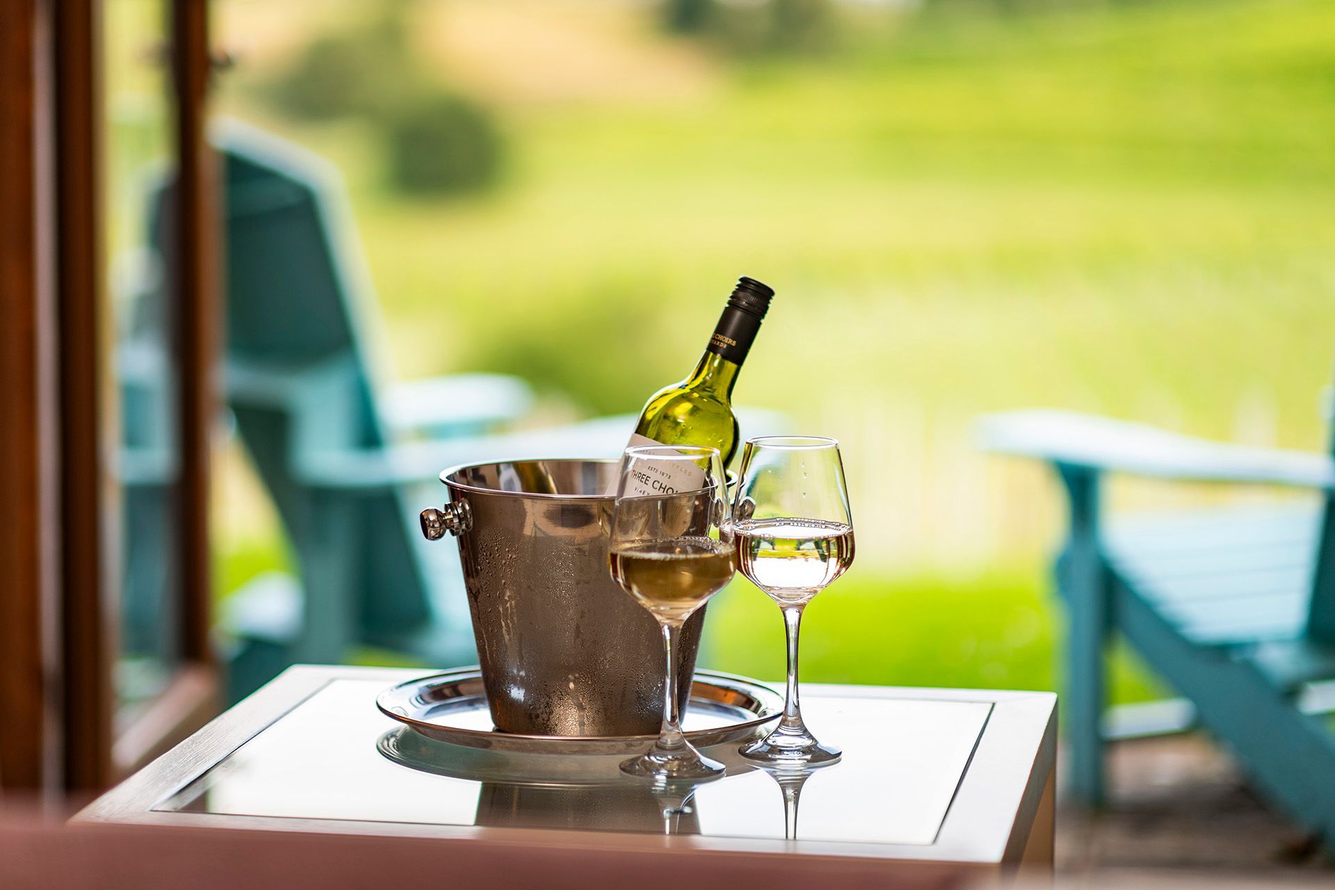 A table with a bottle of wine and two glasses on it.