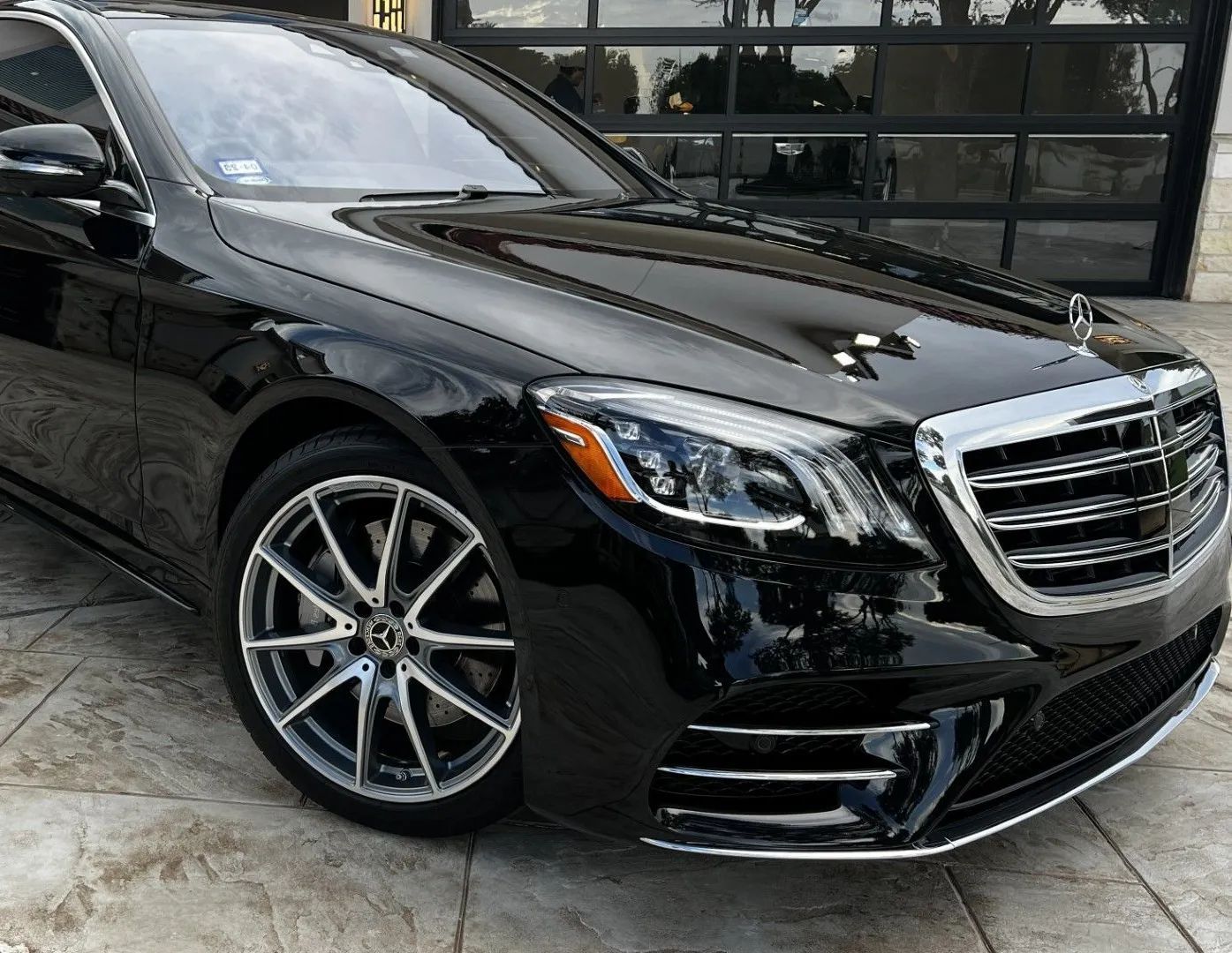 Black Mercedes-Benz sedan, parked outdoors, with chrome accents and alloy wheels.