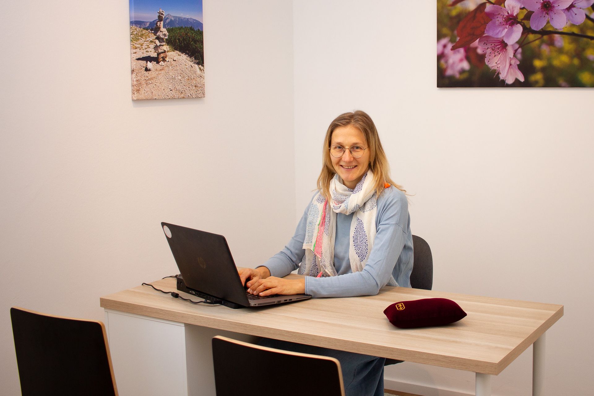Dr. Yvonne Gergely sitzt auf ihrem Schreibtisch vor ihrem Laptop in der Ordination